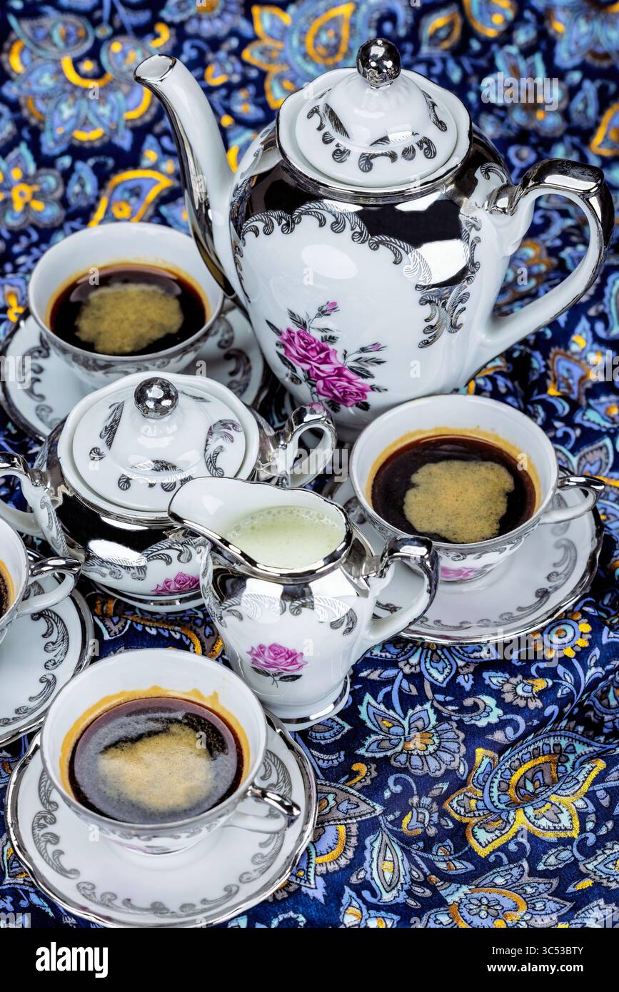 Set aus Vintage Porzellan Kaffeetassen auf farbenfrohem abstraktem Hintergrund, von oben gesehen Stockfoto