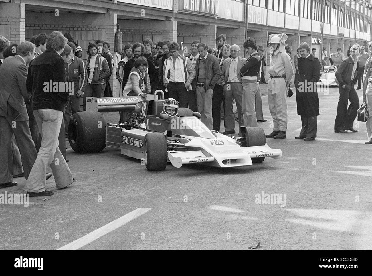 Michael Bleekemolen auf dem Circuit Zandvoort Race, Zandvoort, Whizgle News, Dutch Desk, Niederlande, 1950-2000 Eine Zuschauermenge versammelt sich um einen Rennwagen in einem Boxenbereich und beobachtet aufmerksam, wie sich ein Fahrer auf die Aktivität vorbereitet. Die Atmosphäre ist voller Spannung und bietet eine Mischung aus lässiger und formeller Kleidung unter den Zuschauern. Mehrere andere Autos und Teammitglieder sind im Hintergrund zu sehen, was die geschäftige Umgebung eines Motorsportanlasses unterstreicht. Stockfoto