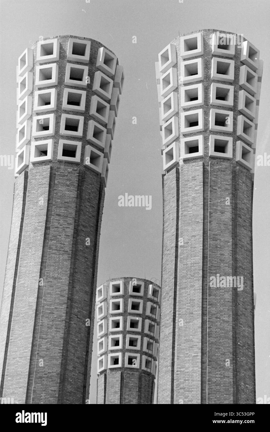Die Luftröhren des Velsertunnels, Velsertunnel, Velsen-Noord, Rijksweg A22, 17-07-1985 Whizgle News, Dutch Desk, Niederlande, 1950-2000 Ein Trio von hoch aufragenden Strukturen mit markanten quadratischen Mustern an der Spitze erhebt sich gegen den Himmel und zeigt eine Mischung aus architektonischer Stärke und geometrischem Design. Das strukturierte Mauerwerk verleiht einen robusten Charakter und verbessert die visuelle Gesamtwirkung. Stockfoto