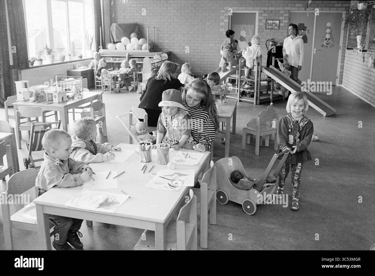 Nieuw Leven Playgroup, Spaarndam, Spaarndam, 23-05-1996 Whizgle News, Dutch Desk, Niederlande, 1950-2000 Eine lebhafte Vorschulumgebung voller Kinder, die verschiedene Aktivitäten ausüben. Einige malen an Tischen aus, andere spielen mit Spielzeug oder interagieren mit Lehrern. Der Raum ist hell und verspielt und sorgt für eine lebhafte Atmosphäre des Lernens und der Kreativität. Stockfoto