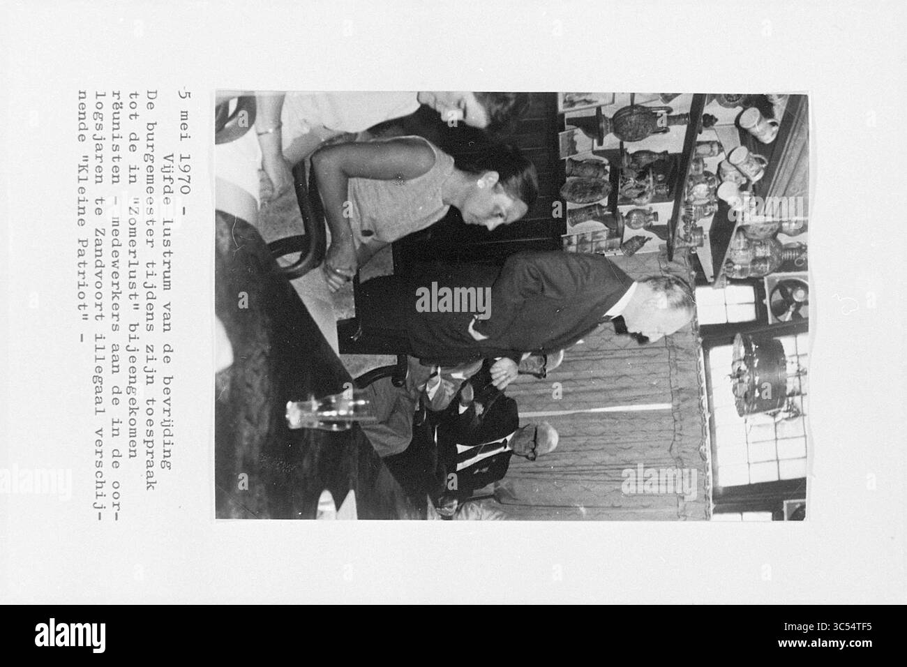 Berichte für Bürgermeister Nawijn, Zandvoort, 22-06-1977 Whizgle News, Dutch Desk, Niederlande, 1950-2000 Ein historisches Treffen zum Jahrestag der Befreiung mit einer Gruppe von Personen, die sich mit Gesprächen beschäftigen, umgeben von bemerkenswerten Bildern und Artefakten an den Wänden. Die Atmosphäre vermittelt ein Gefühl der Reflexion und Bedeutung, geprägt durch eine formale Präsentation oder Rede. Stockfoto