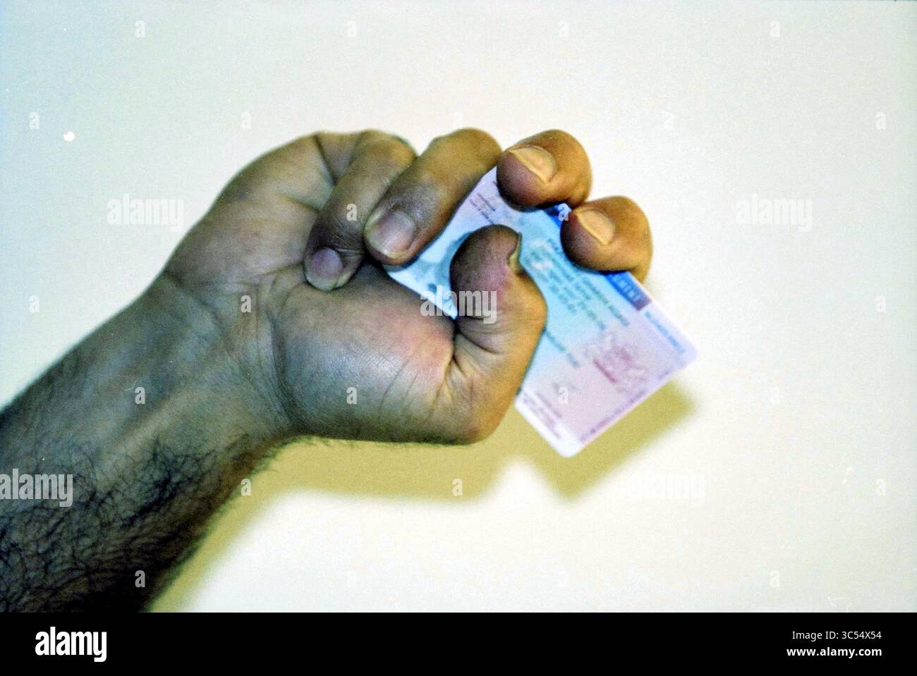 Familie Eskamdarie, Haarlem, Niederlande, 31-07-2001, Whizgle News, Dutch Desk, Niederlande, 1950-2000 Eine geballte Hand hält eine Karte fest und zeigt ein Gefühl der Entschlossenheit oder Betonung. Stockfoto