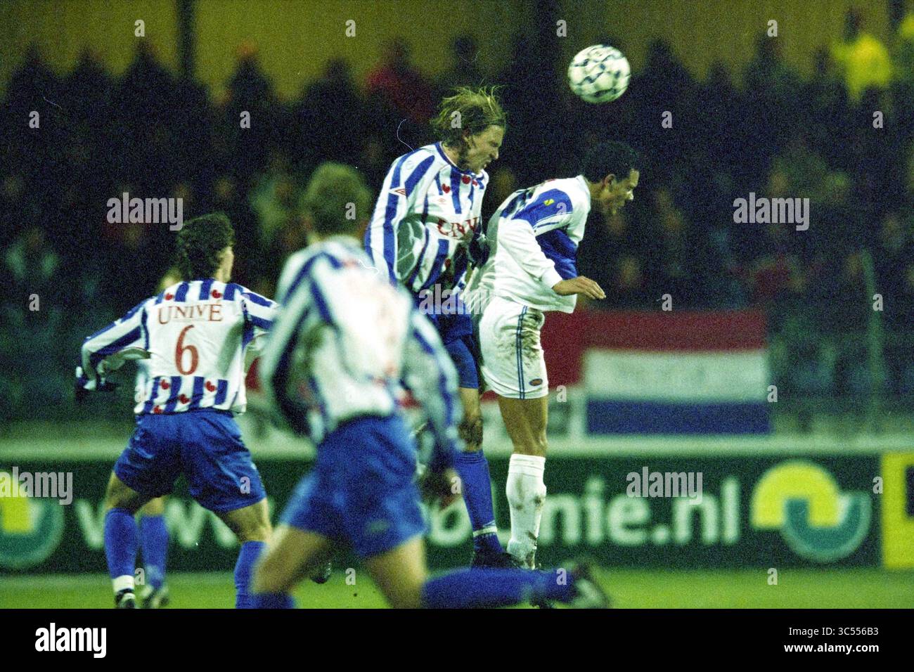 Football, Telstar - Heerenveen, 03-02-2003 Whizgle News, Dutch Desk, Niederlande, 1950-2000 Ein dynamischer Moment während eines Fußballspiels, in dem Spieler in Aktion sind, während ein Athlet springt, um den Ball zu besiegen, während Teamkollegen und Gegner das Spiel vorwegnehmen. Der Hintergrund zeigt Fans und Flaggen, was die Wettbewerbsatmosphäre verstärkt. Stockfoto