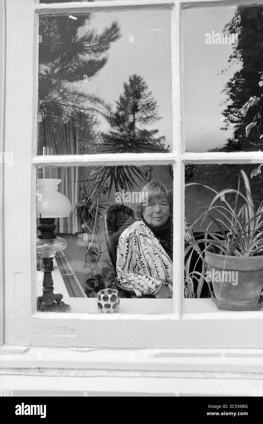 COBI Schreijer (1922-2005), "die 10 Fragen", Haarlem, Niederlande, 16-11-1992 Whizgle News, Dutch Desk, Niederlande, 1950-2000 Eine Person sitzt bequem in einem gemütlichen Innenbereich, umgeben von Pflanzen und weichen Möbeln, und blickt durch ein Fenster. Die Szene wird von einer großen Glasscheibe eingerahmt, die sowohl das Grün draußen als auch die Wärme des Innenraums reflektiert. Stockfoto COBI Schreijer (1922-2005), "die 10 Fragen", Haarlem, Niederlande, 16-11-1992 Whizgle News, Dutch Desk, Niederlande, 1950-2000 Eine Person sitzt bequem in einem gemütlichen Innenbereich, umgeben von Pflanzen und weichen Möbeln, und blickt durch ein Fenster. Die Szene wird von einer großen Glasscheibe eingerahmt, die sowohl das Grün draußen als auch die Wärme des Innenraums reflektiert. Stockfoto