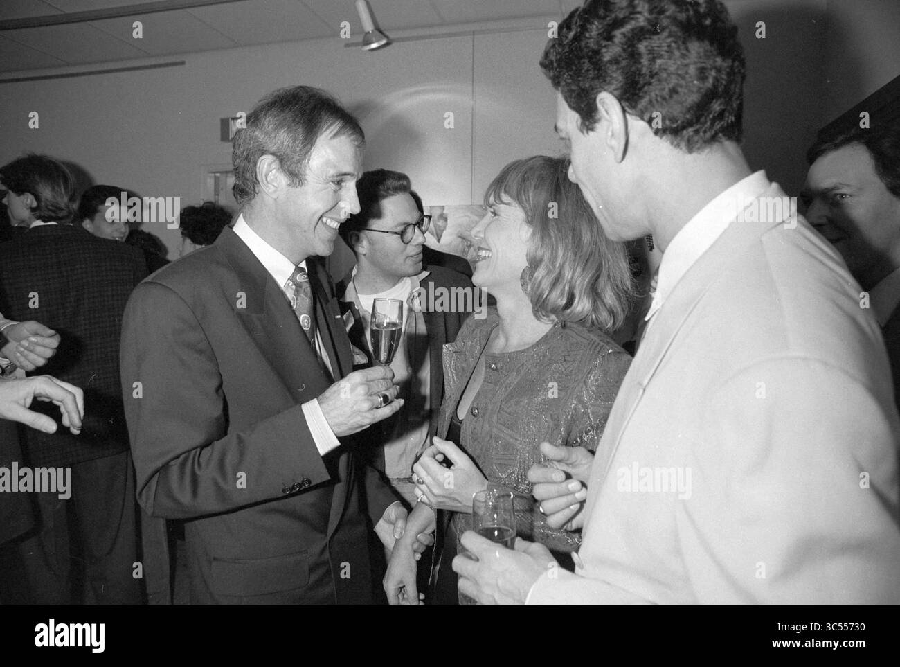 Revue Revue IJmuiden, IJmuiden, Niederlande, 17-12-1991 Whizgle News, Dutch Desk, Niederlande, 1950-2000 Eine Gruppe von Menschen führt bei einem geselligen Treffen lebhafte Gespräche, mit Lächeln und Lachen, während sie Getränke und die Gesellschaft des anderen genießen. Die Atmosphäre ist festlich und unterstreicht die Interaktionen und Verbindungen zwischen den Teilnehmern. Stockfoto