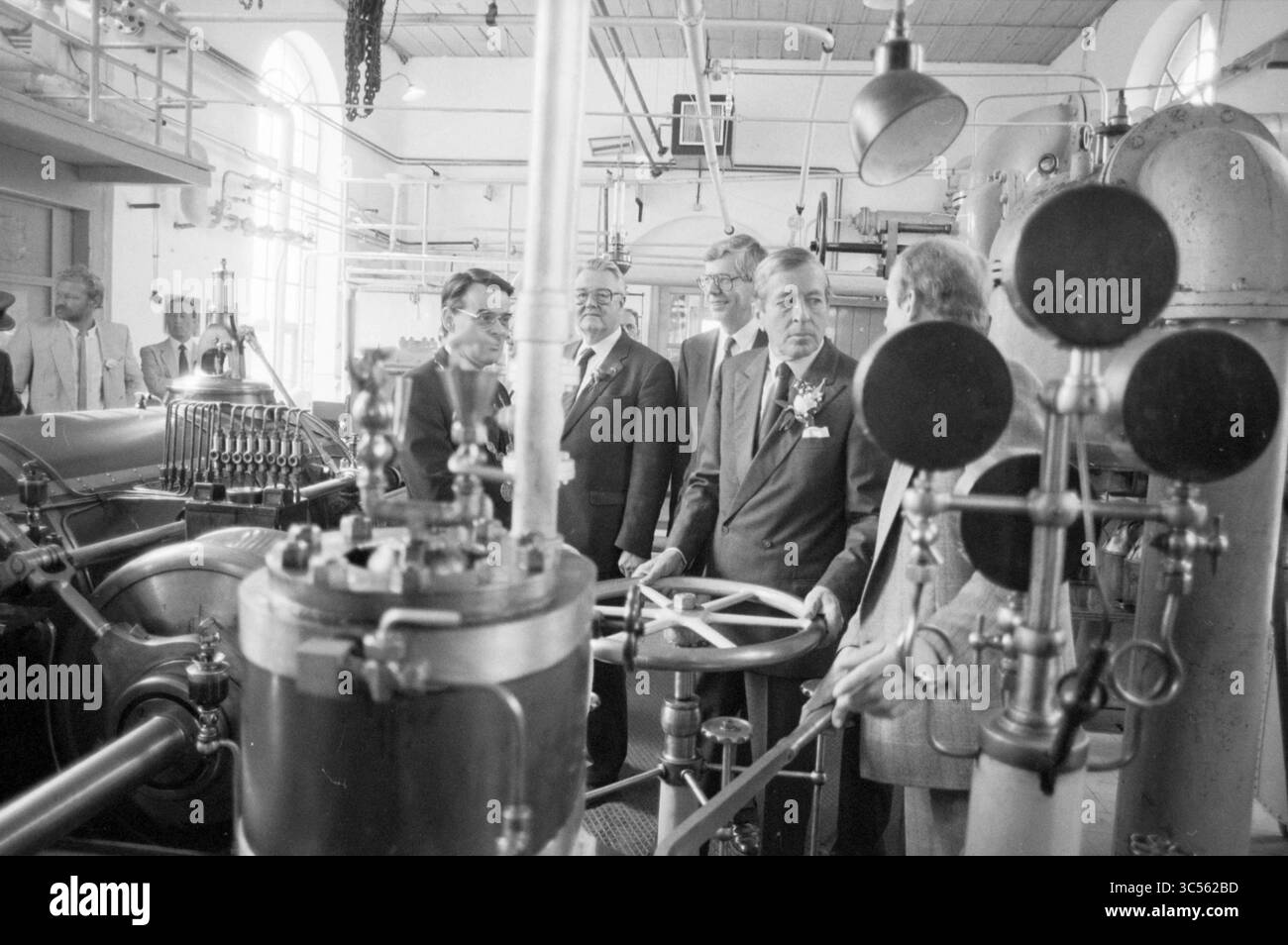 Öffnung der Dampfpumpenstation auf halbem Wege durch Prinz Claus, Öffnung, Öffnungen, Inbetriebnahme, Halfweg, 09-06-1987 Whizgle News, Dutch Desk, Niederlande, 1950-2000 Eine Gruppe von Männern versammelt sich in einem historischen industriellen Umfeld um komplizierte Maschinen, untersucht die komplexe Ausrüstung und führt Gespräche, während sie die Handwerkskunst der Epoche vorstellt. Stockfoto