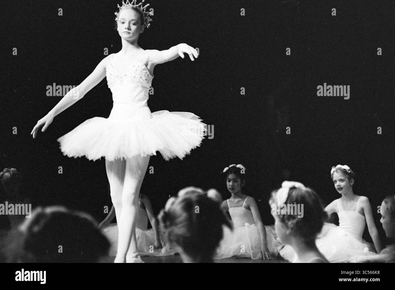 Ballettvorstellung, 00-05-1988 Whizgle News, Dutch Desk, Niederlande, 1950-2000 Eine anmutige Ballerina tritt in einem atemberaubenden Tutu auf und zeigt ihre Eleganz und Ausgeglichenheit auf der Bühne, während eine Gruppe junger Tänzer aufmerksam von der Seitenlinie aus zusieht, die darauf begierig sind, zu lernen und sich inspirieren zu lassen. Stockfoto