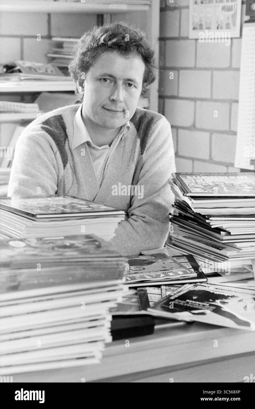 Hans van de Boom, Herausgeber von Arboris, 24-03-1986 Whizgle News, Dutch Desk, Niederlande, 1950-2000 Eine nachdenkliche Einzelperson posiert an einem Schreibtisch, der mit zahlreichen Magazinen und Kunstmaterialien überfüllt ist und einen kreativen Geist inmitten eines organisierten Chaos künstlerischer Ressourcen ausstrahlt. Stockfoto