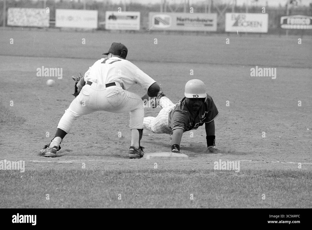 Baseball, Hoofddorp - ADO, 25-06-1994 Whizgle News, Dutch Desk, Niederlande 1950-2000 Ein Spieler rutscht in die Basis, während ein Feldspieler versucht, ihn zu markieren, um die Intensität des Spiels zu zeigen. Stockfoto