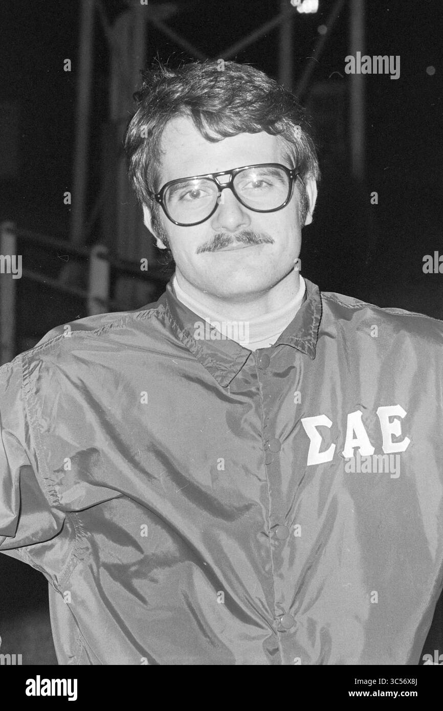 Amerikanische Baseballspieler Hit Nicols, Baseball, 12-04-1973 Whizgle News, Dutch Desk, Niederlande, 1950-2000 Ein Mann mit Brille und Schnurrbart steht zuversichtlich, gekleidet in eine Jacke mit griechischen Buchstaben. Sein Ausdruck ist ernst, aber ansprechbar, was auf ein Gefühl von Kameradschaft und Schulgeist hindeutet. Stockfoto