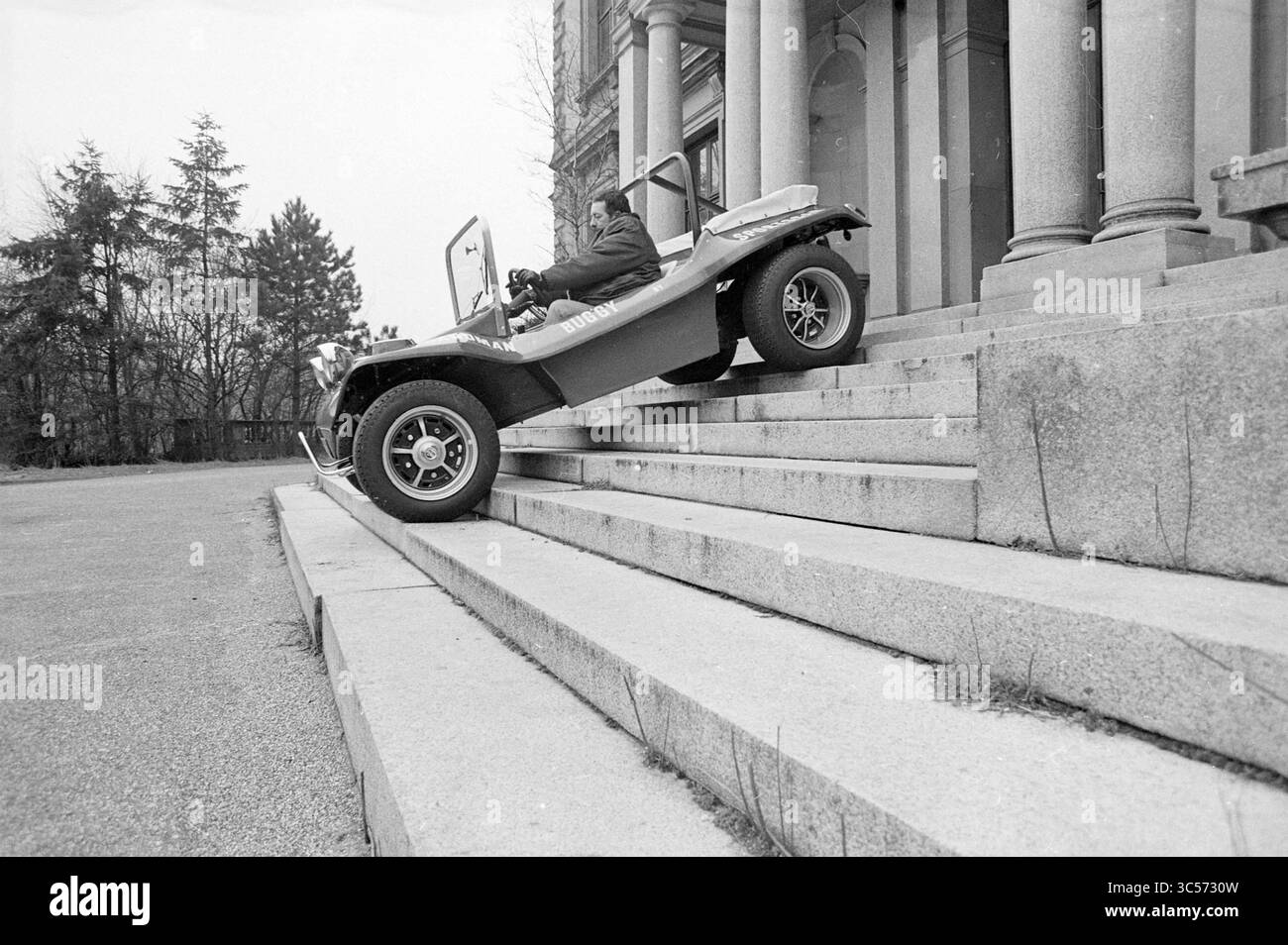 Auto, Buggy, on Treppen Whizgle News, Dutch Desk, Niederlande, 1950-2000 Eine Person, die ein kleines, einzigartiges Fahrzeug fährt, steigt eine Reihe großer Steintreppen hinab und zeigt einen abenteuerlichen Geist in einer ungewöhnlichen Umgebung. Stockfoto