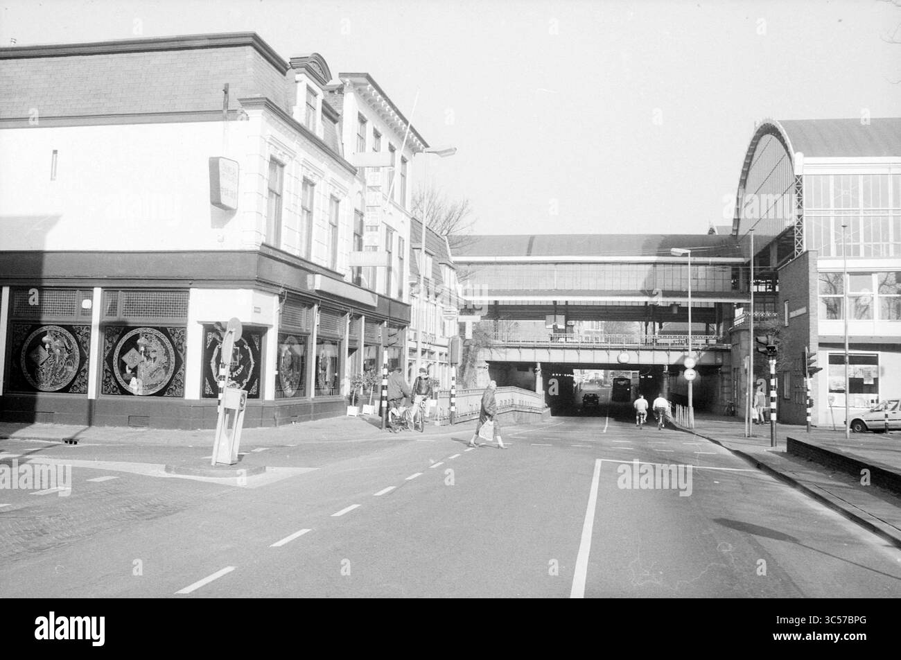 Ext. Restaurant Chang Au, Kruisweg, Haarlem, Restaurant, Haarlem, Kruisweg, Niederlande, 08-02-1989 Whizgle News, Dutch Desk, Niederlande, 1950-2000 eine urbane Szene mit einer Straßenecke und einem historischen Gebäude mit dekorativen Wandmalereien. Eine Eisenbahnpassage führt über den Kopf, während Fußgänger und Radfahrer die Straße darunter befahren und das tägliche Leben mit architektonischen Wahrzeichen verbinden. Stockfoto