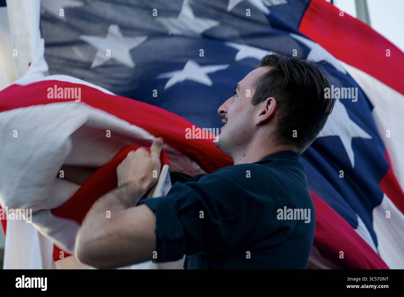 4. Januar 2020: Quartiermaster 3rd Class Steven Pettit aus Long Island, New York, senkt die Nationalflagge an Bord des Flugzeugträgers USS Abraham Lincoln (CVN 72). Die Abraham Lincoln Carrier Strike Group wird im Einsatzgebiet der 7. US-Flotte eingesetzt, um die Sicherheit und Stabilität in der indopazifischen Region zu unterstützen. Mit Abraham Lincoln als Flaggschiff wurden Stab und Flugzeuge der Carrier Strike Group (CSG) 12, der Destroyer Squadron (DESRON) 2 und des Carrier Air Wing (CVW) 7 eingesetzt. (Kreditbild: © U.S. Navy/ZUMA Wire/ZUMAPRESS.com) Stockfoto