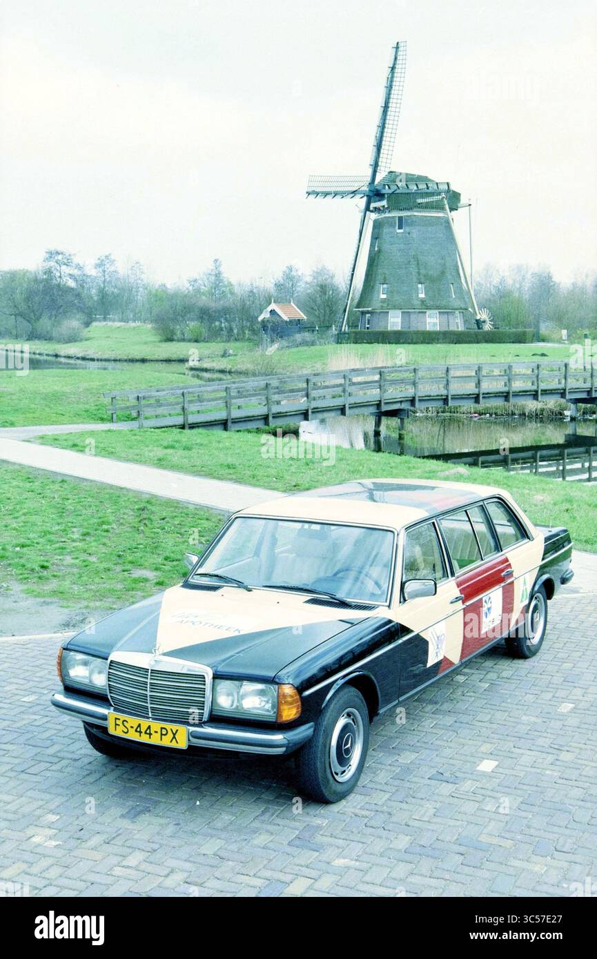 Mercedes @@, 24-03-1997 Whizgle News, Dutch Desk, Niederlande, 1950-2000 Eine klassische Limousine mit markantem Schwarz-weiß-Farbauftrag steht neben einer malerischen Windmühle, umgeben von üppigem Grün und ruhigem Wasser. Stockfoto