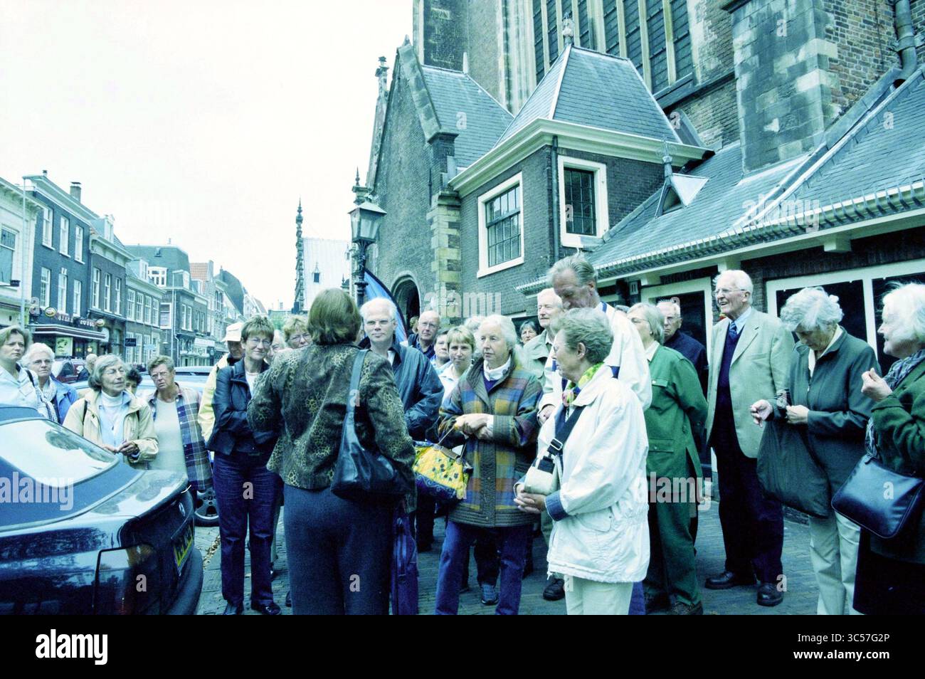 Sponsoren Day Prince Bernhard Fund, 01.10.2003 Whizgle News, Dutch Desk, Niederlande, 1950-2000 Eine große Gruppe von Menschen versammelt sich vor einem historischen Gebäude, um sich zu unterhalten. Eine Person scheint sich an die Gruppe zu wenden, während andere aufmerksam zuhören. Das Ambiente bietet klassische Architektur, und einige Fahrzeuge stehen in der Nähe, was die lebhafte Atmosphäre der Szene unterstreicht. Stockfoto