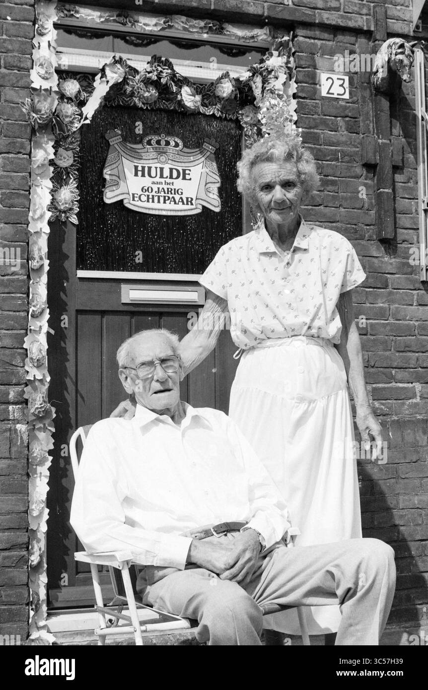 Familie Seeer heiratete 60 Jahre, Paare, 08-08-1988 Whizgle News, Dutch Desk, Niederlande, 1950-2000 ein älteres Ehepaar steht stolz vor ihrem geschmückten Hauseingang mit einem Schild, das ihre langjährige Partnerschaft feiert. Der Mann sitzt auf einem Stuhl, während die Frau neben ihm steht und Wärme und Gesellschaft ausstrahlt. Stockfoto