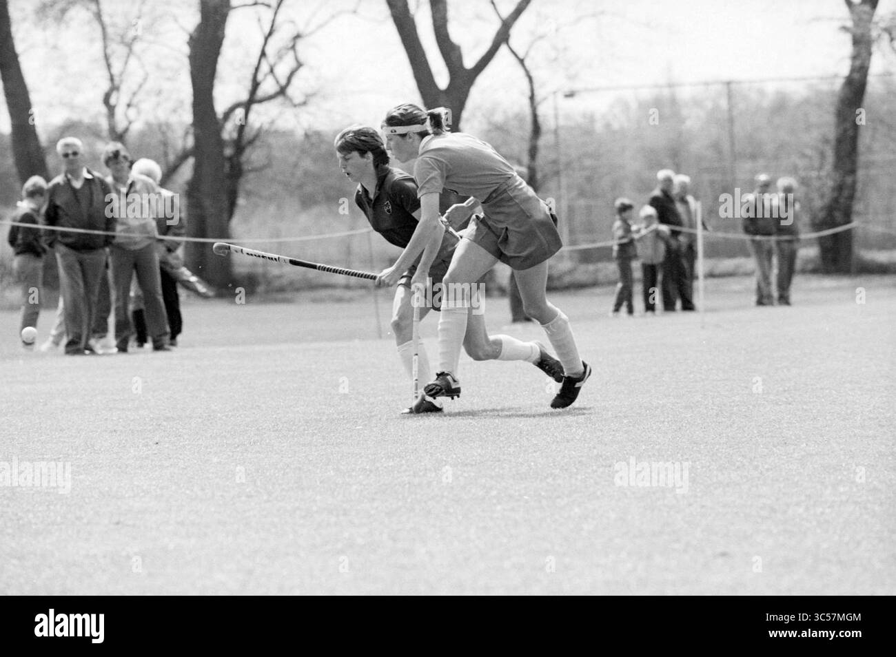 HBS - Bloemendaal, Ladies, Hockey, 13-05-1984 Whizgle News, Dutch Desk, Niederlande, 1950-2000 zwei Spieler konzentrieren sich intensiv auf ein Feldhockeyspiel, wobei ein Spieler den Ball dribbelt, während der andere den Ball genau verfolgt. Die Zuschauer treffen sich im Hintergrund und beobachten die Action auf dem Spielfeld. Die Atmosphäre ist konzentriert und konkurrenzfähig. Stockfoto