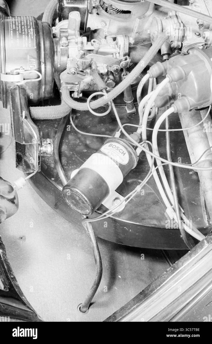 Motor unter der Motorhaube Whizgle News, Dutch Desk, Niederlande, 1950-2000 ein komplizierter Blick auf die Motorkomponenten eines Autos mit verschiedenen Teilen wie Schläuchen, Drähten und einer Bosch-Einheit, die die Komplexität der Fahrzeugtechnik unterstreicht. Stockfoto