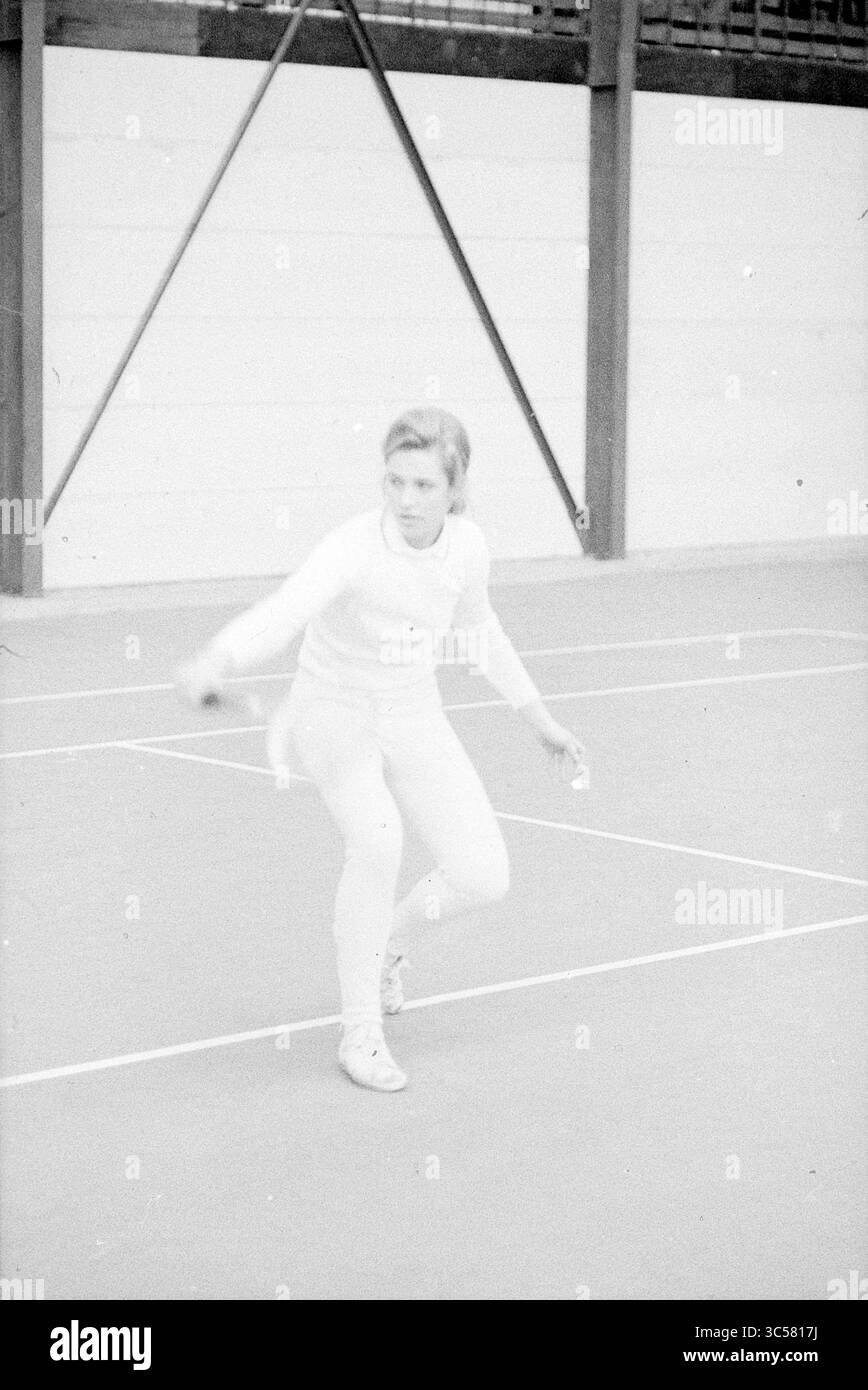 Porträts Frau, die Tennis spielt in Halle Whizgle News, Dutch Desk, Niederlande, 1950-2000 eine Athletin bereitet sich auf einen Tennisball vor und zeigt fokussierte Entschlossenheit und athletische Form auf dem Platz. Stockfoto