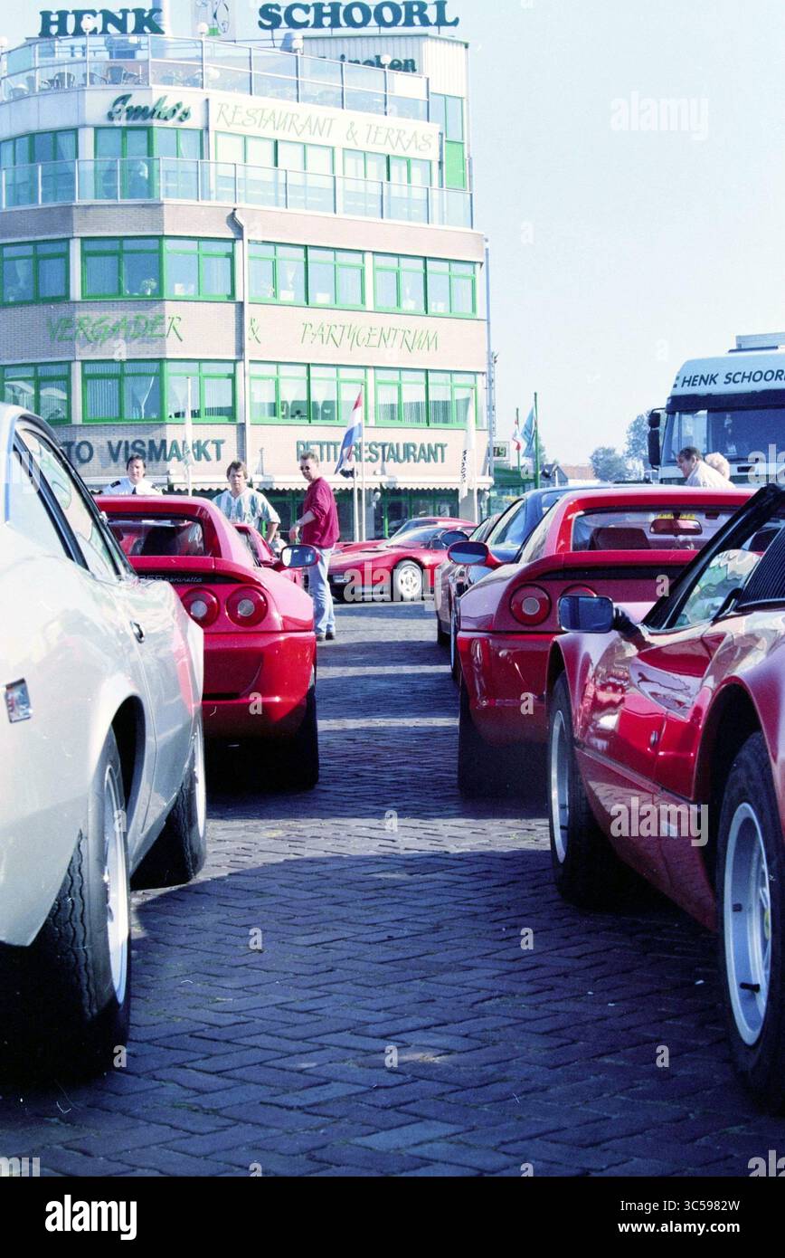 Ferrari Club, Henk Schoorl, IJmuiden, IJmuiden, Niederlande, 25-09-1997 Whizgle News, Dutch Desk, Niederlande, 1950-2000 vor einem belebten Restaurant und einer Terrasse parken klassische Sportwagen, die überwiegend in leuchtendem Rot gehalten sind. In der Nähe mischen sich die Enthusiasten und schaffen eine energiegeladene Atmosphäre. Stockfoto