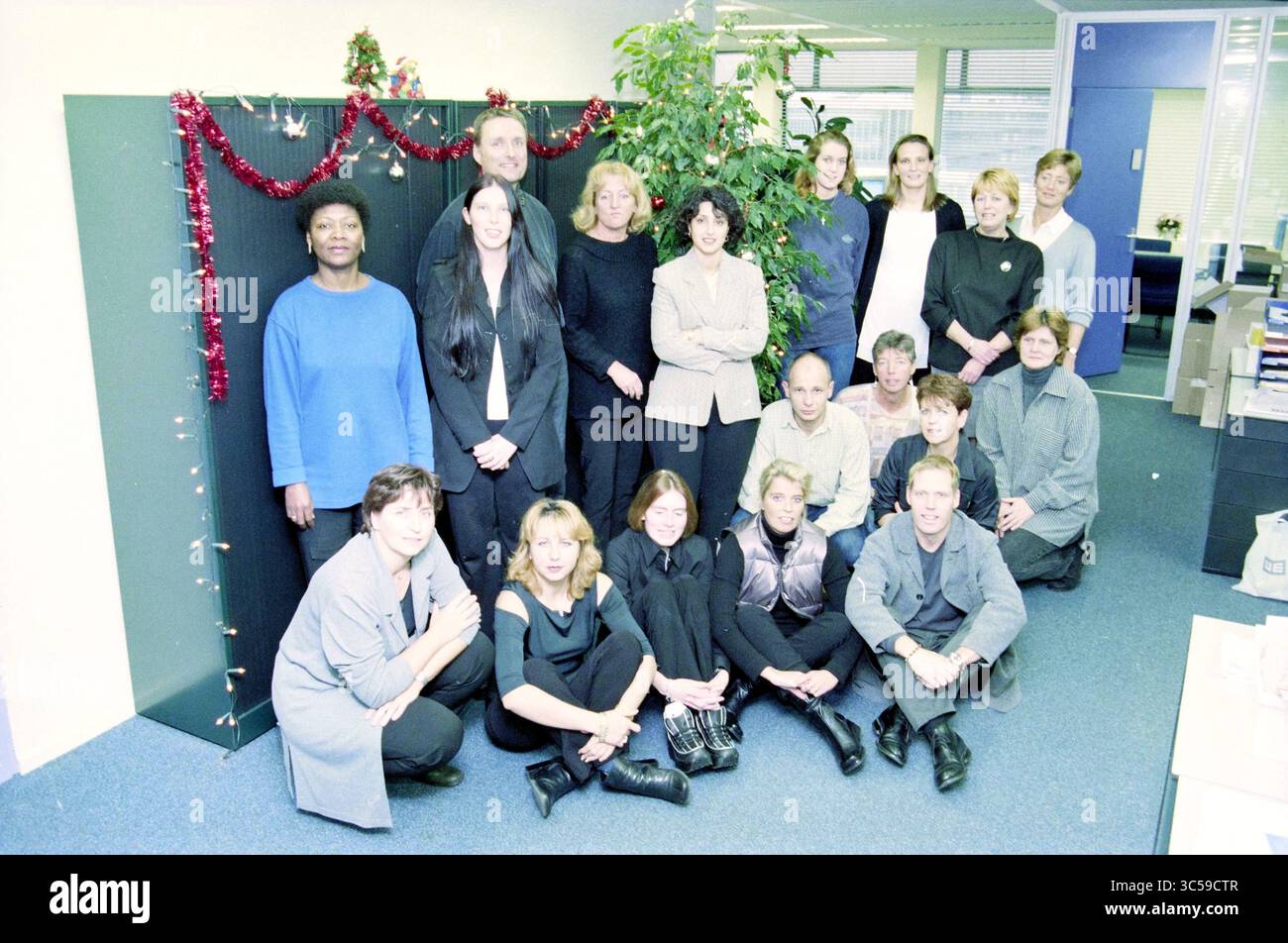 Gruppen Haarlem Zilveren Kruis, Achmea, Haarlem, Niederlande, 08-11-2000 Whizgle News, Dutch Desk, Niederlande, 1950-2000 In einem festlichen Büro versammelt sich Eine vielfältige Gruppe von Mitarbeitern, die sich vor einer dekorierten Kulisse gemeinsam posieren. Die Atmosphäre verströmt ein Gefühl von Kameradschaft und Urlaubsgeist, mit Individuen, die in einer Vielzahl von legeren professionellen Kleidern gekleidet sind. Stockfoto