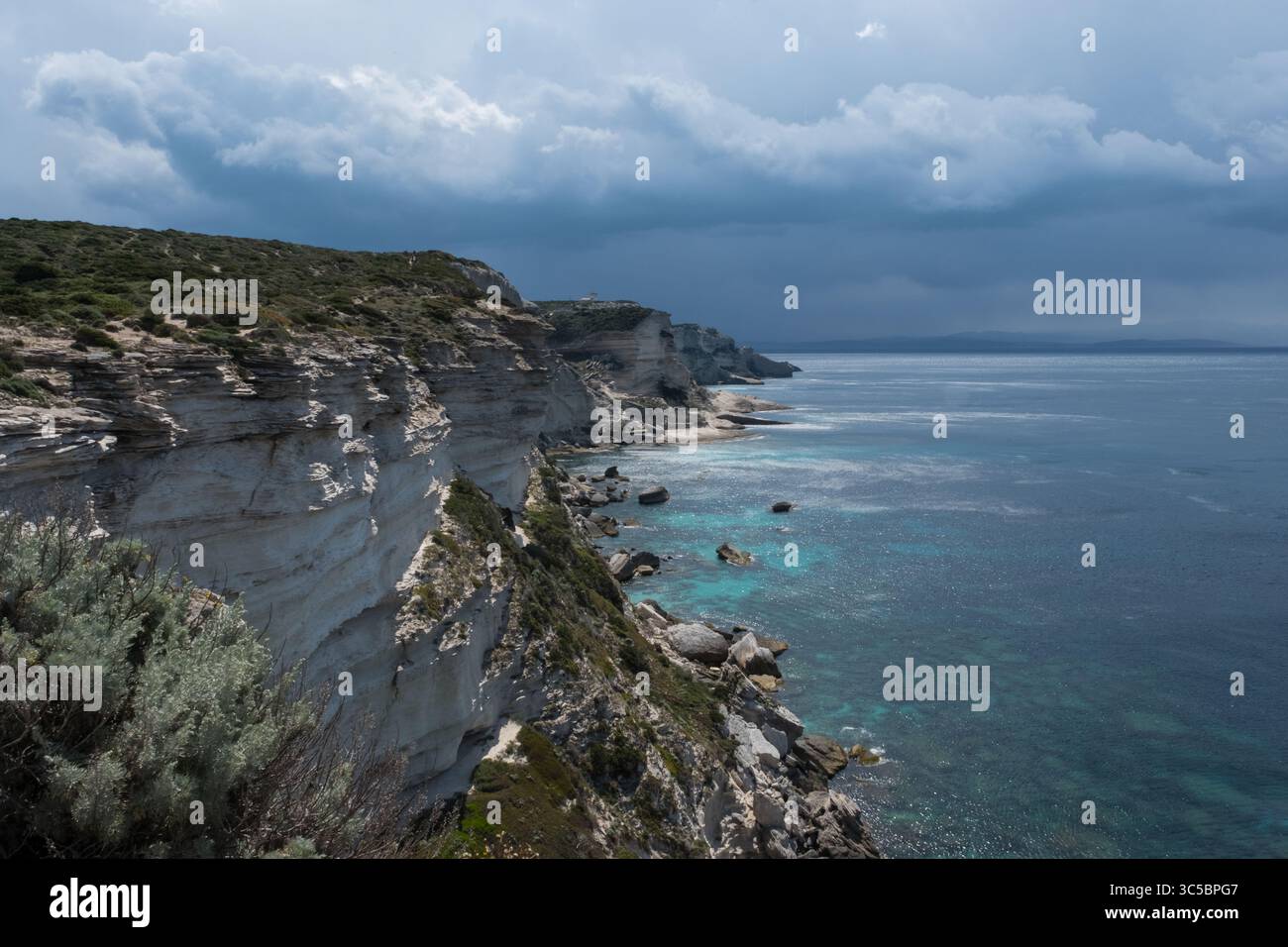 Eindrucksvolle Küstenklippen in Korsika, Frankreich, die sich über dem Mittelmeer erheben, mit dramatischem Licht und Texturen. Eine raue Naturlandschaft Stockfoto