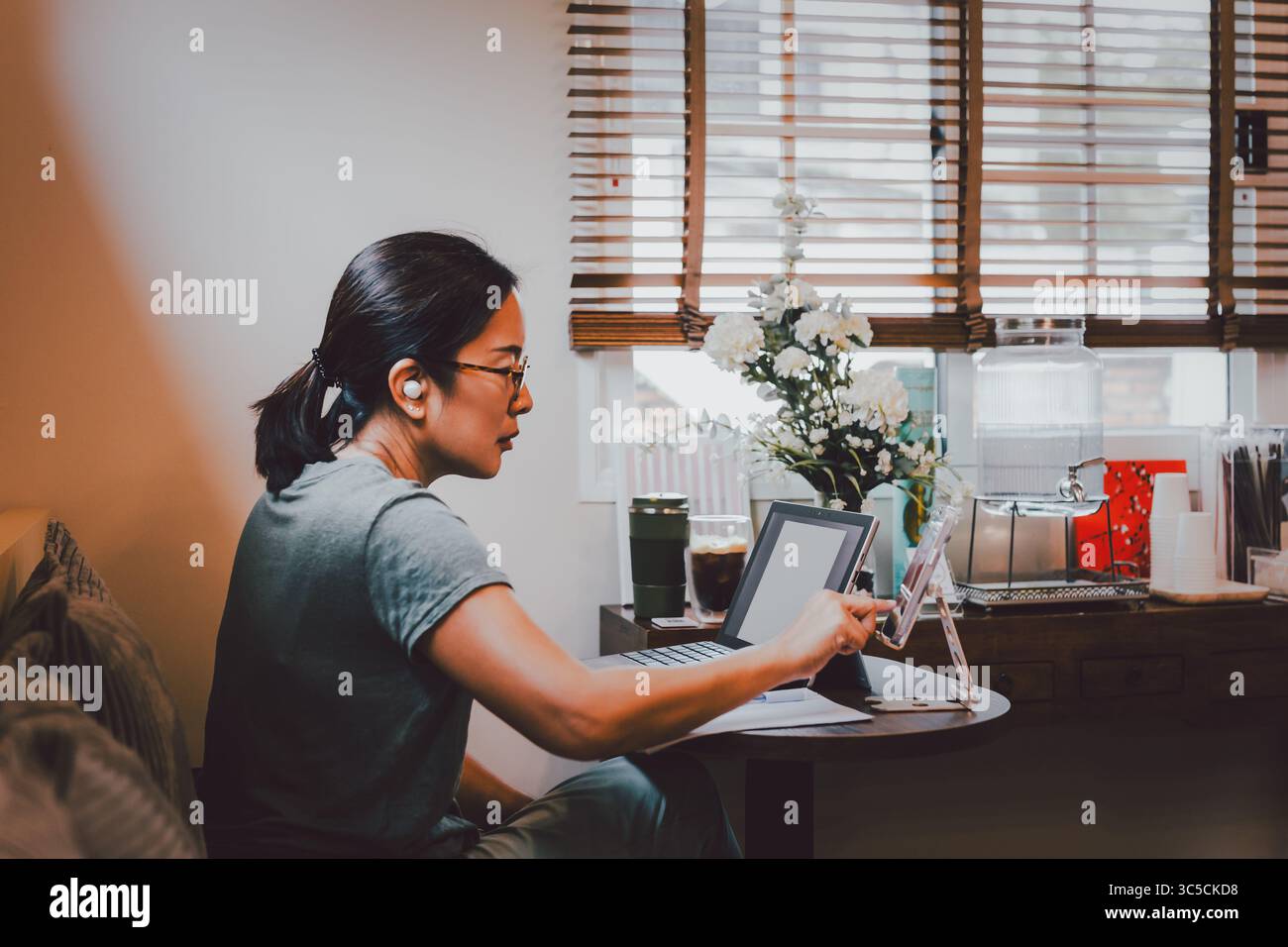 Geschäftsfrau Hand mit Handy und Laptop auf Tisch. Stockfoto