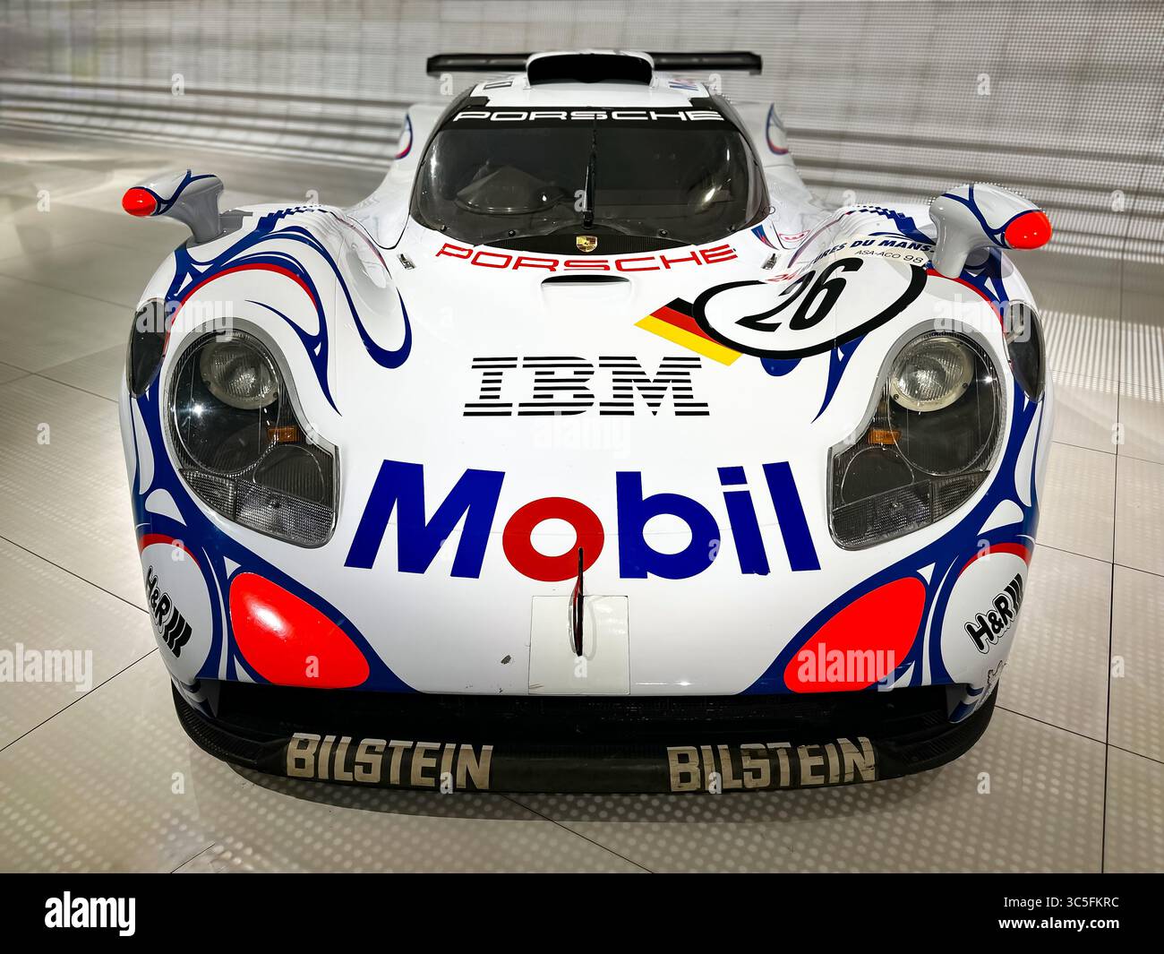 Vorderansicht eines farbenfrohen Porsche GT1 Rennwagens mit lebhaften Sponsorlackierungen, die Motorsport-Design, Geschwindigkeit und Renntradition hervorheben. Stockfoto