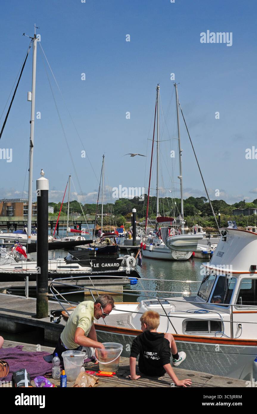 Leute, die am Lymington Harbour Kai krabben. Stockfoto