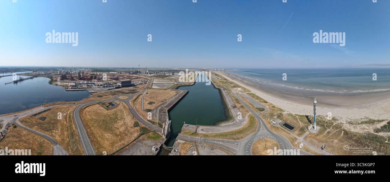 Aus der Vogelperspektive auf eine Wasserstraße, die durch die Landschaft führt, wo Industriegebäude auf den ruhigen Strand treffen, Dünkirchen, Nord, Frankreich. Stockfoto