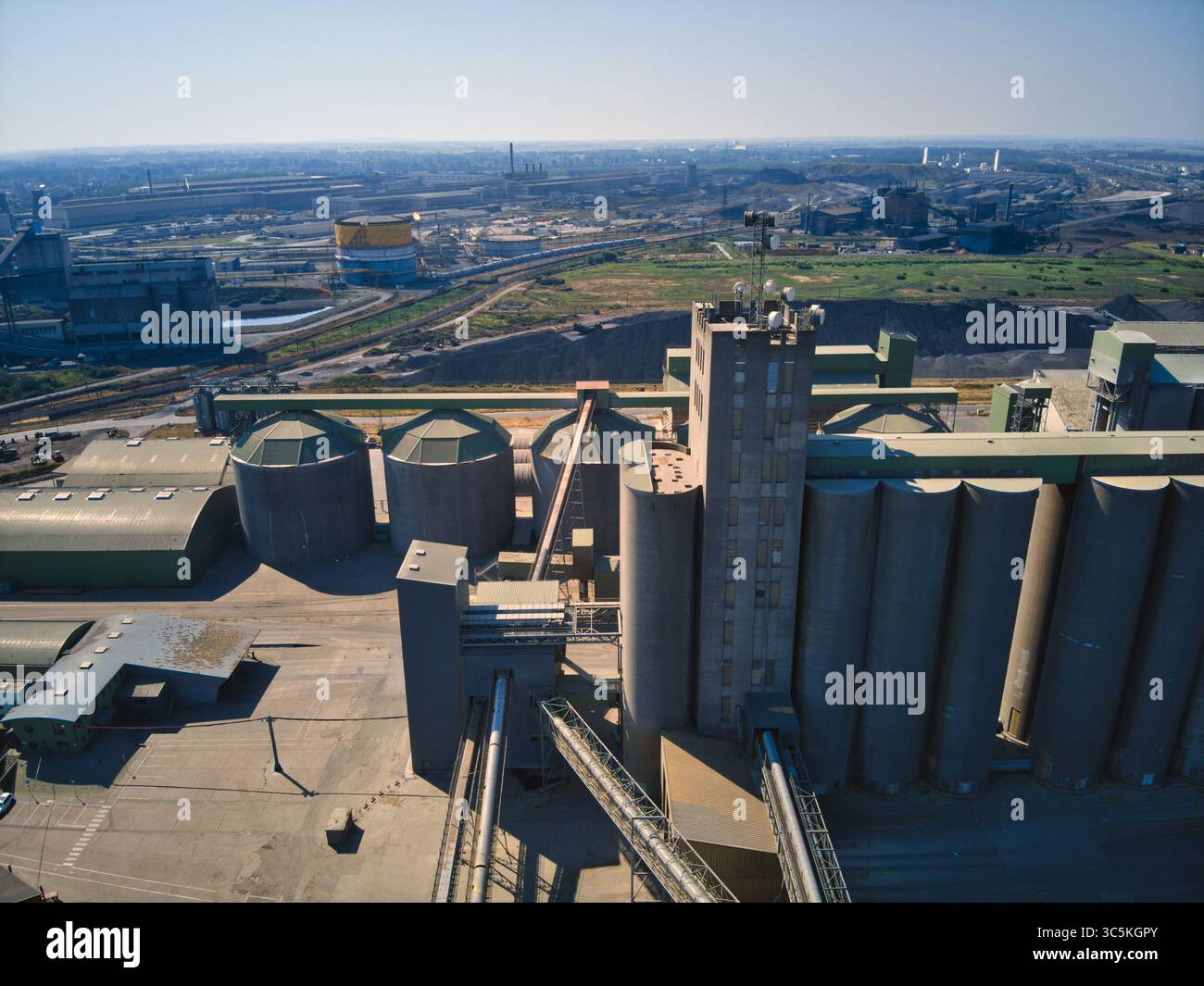 Luftaufnahme von Industriestrukturen, die unter dem klaren Himmel schattenspendende Sinfonie aus Beton und Stahl, Dunkirk, Nord, Frankreich. Stockfoto