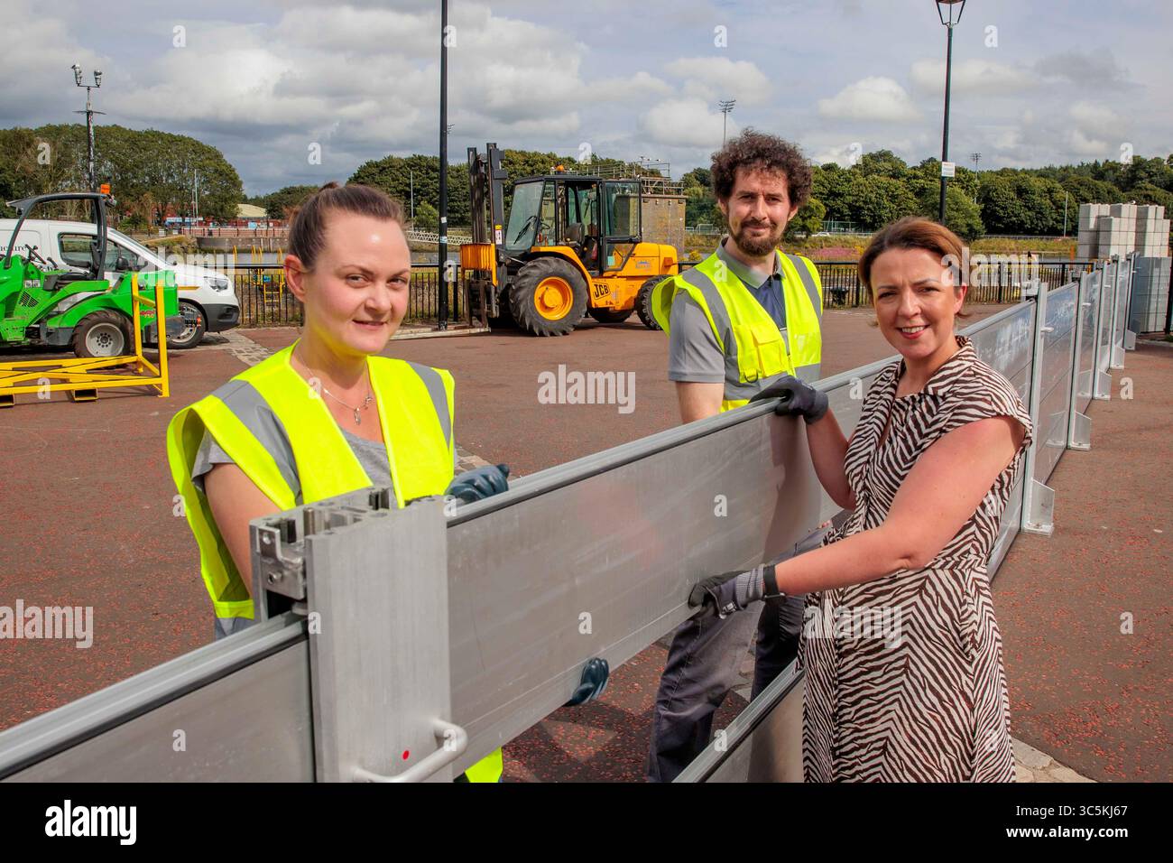 Infrastrukturministerin Liz Kimmins mit Emily Johnston (links), Professional Technical Officer (PTO) und Alan McWatters, Greater Belfast Area Engineer für DFI und Gary Quinn, stellvertretender Direktor für Flüsse im Department for Infrastructure (DFI) während einer groß angelegten Schulungsübung am Ufer des Lagan in Belfast, die zeigt, wie die Hochwasserschutzanlagen in Belfast im Falle einer Flutwelle vollständig in Betrieb gehen würden. Die Übung umfasst die Installation und anschließende Demontage von ca. 1500 m provisorischen Hochwasserschutzanlagen, die als Teil genutzt werden sollen Stockfoto