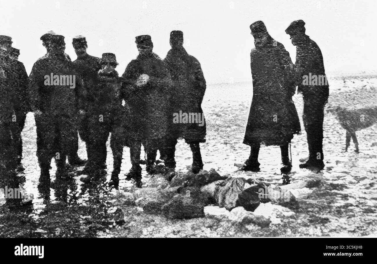 Französische Soldaten untersuchen die Leiche eines deutschen feldwebels, der vor dem Absturz aus der Zeppelingondel gesprungen ist. Dieses düstere Bild wurde 1916 in matschigem Gelände in der Nähe von Revigny aufgenommen und spiegelt den menschlichen Tribut des Luftschiffkrieges und die düsteren Nachwirkungen der abgestürzten feindlichen Besatzungen während des Weltkrieges wider, die ISnow vor kurzem gefallen war und den Boden in einer kalten, winterlichen Landschaft, die typisch für Nordostfrankreich war, im Februar 1916 bedeckt. Stockfoto