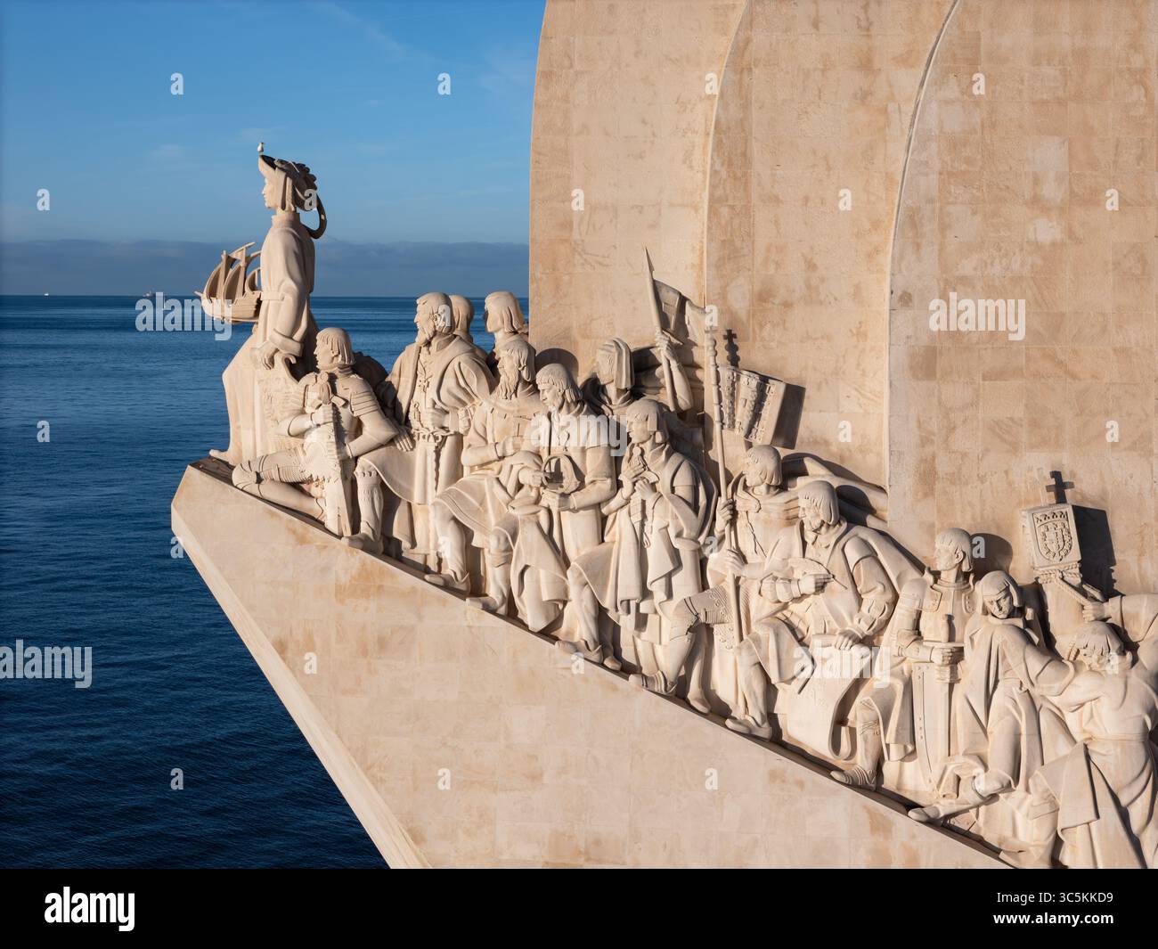 Aus der Vogelperspektive ragt das weiße Padrão dos Descobrimentos-Denkmal in das tiefblaue Meer, Lissabon, Lisboa, Portugal. Stockfoto