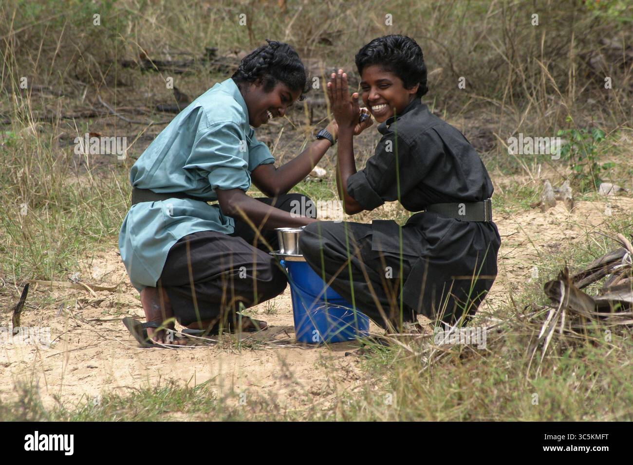 9. April 2005, Mullaitivu, Sri Lanka: Tamil Tigers Woman serviert Limonade nach Rückkehr von der Patrouille. Die Liberation Tigers of Tamil Eelam war eine militante Organisation, die im Nordosten Sri Lankas stationiert war. Ziel war es, einen unabhängigen Staat Tamil Eelam im Norden und Osten zu sichern, als Reaktion auf die staatliche Politik der sukzessiven Regierungen Sri Lankas gegenüber Tamilen. Gegründet am 5. Mai 1976 und militärisch besiegt im Mai 2009. Frauen spielten eine wichtige Rolle in der LTTE-Armee und haben eigene Brigaden, die mit den regulären Infanterie-, Artillerie- und Marinestruppen zusammenarbeiten Stockfoto