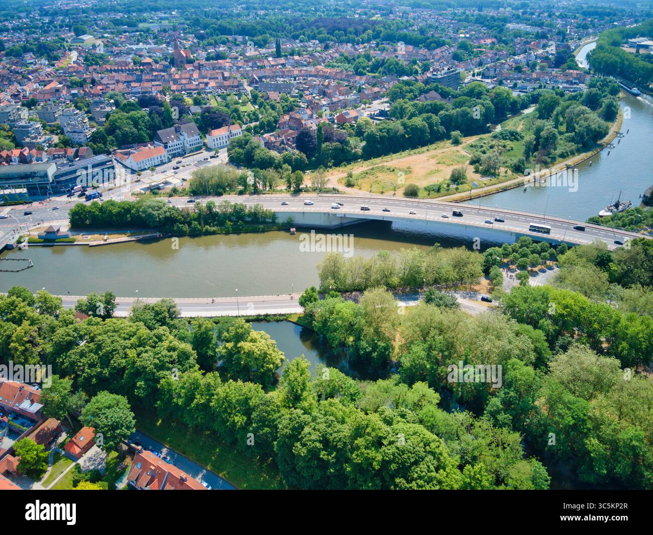 Blick aus der Vogelperspektive auf Brücken, die die ruhigen Wasserstraßen überqueren, umgeben von üppigem Grün und der städtischen Landschaft, Brügge, Flandern, Belgien. Stockfoto