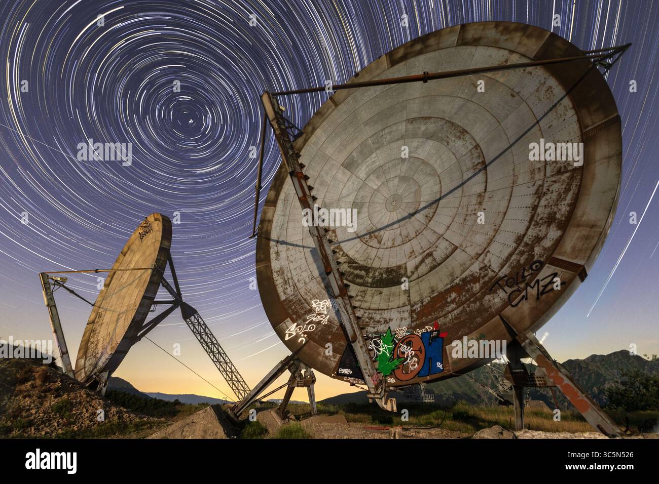 Ex NATO Base IMXZ Giogo Mount, Comano, Toskana. Verlassene Radarschalen unter faszinierenden Sternenpfaden. Eine surreale Mischung aus Relikten des Kalten Krieges und Astrofotografie Stockfoto