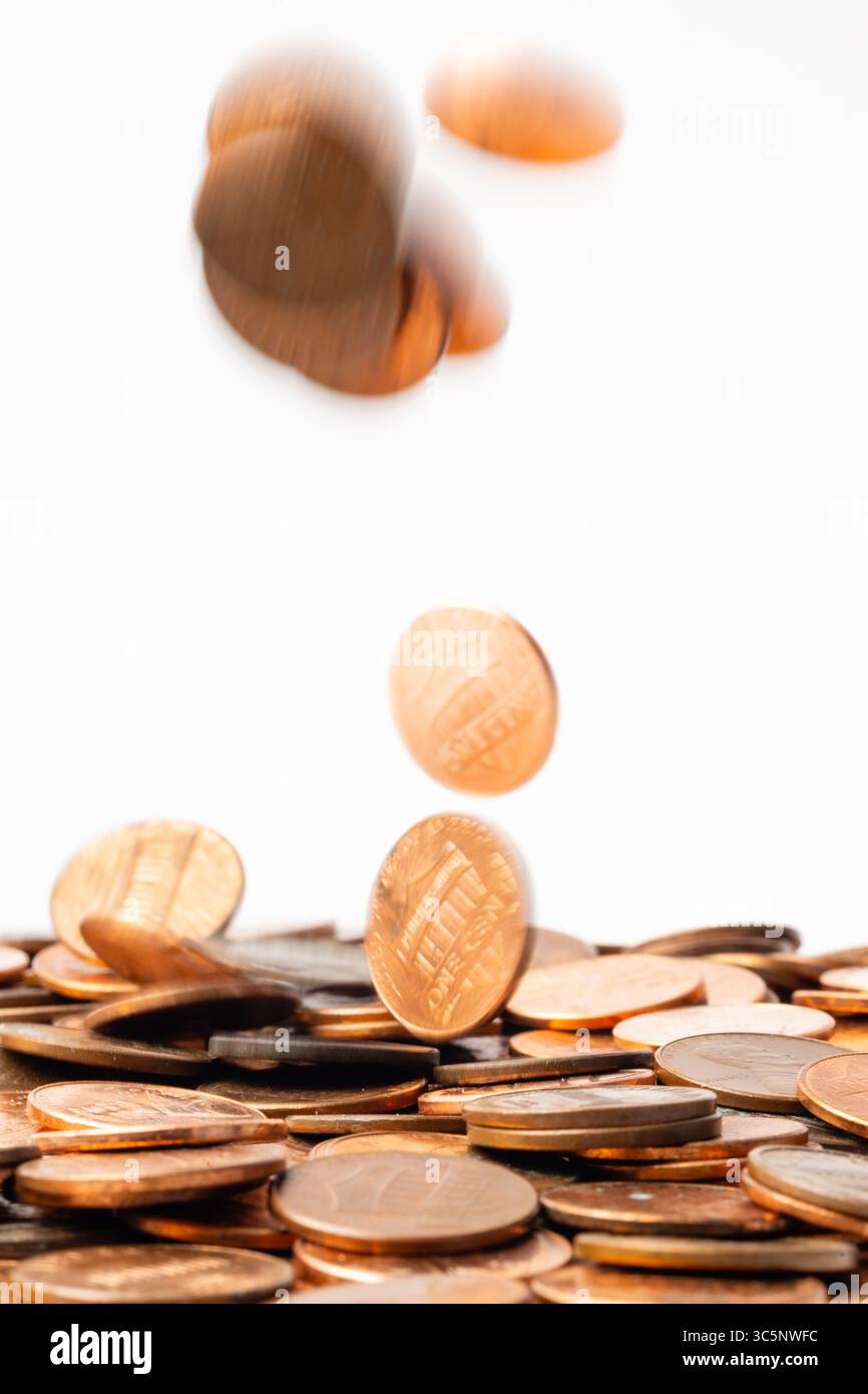 Pennys in Bewegung fallen in einen Haufen Stockfoto