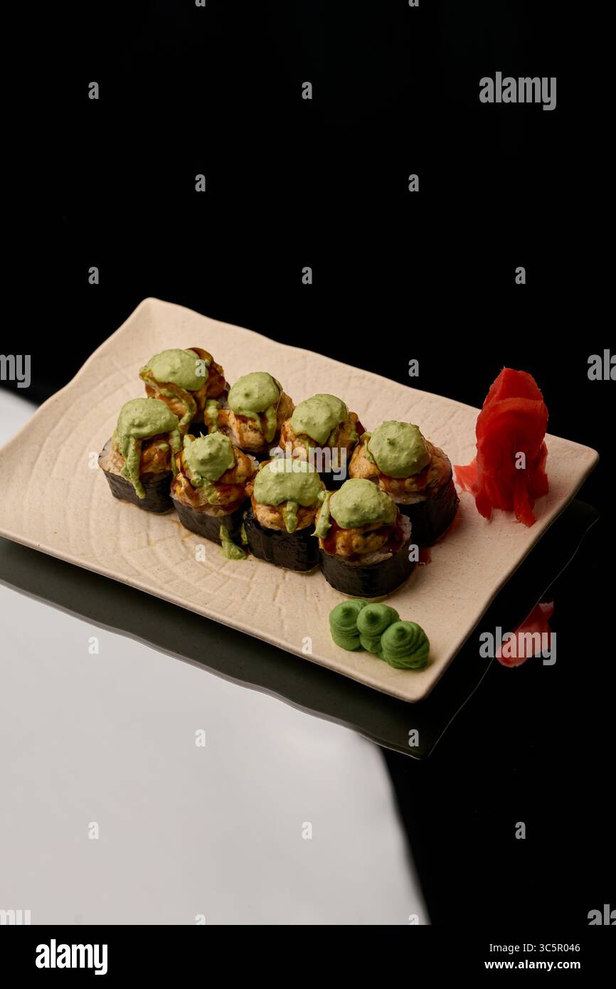 japanische Küche. Sushi auf einem Teller auf schwarzem Hintergrund Stockfoto