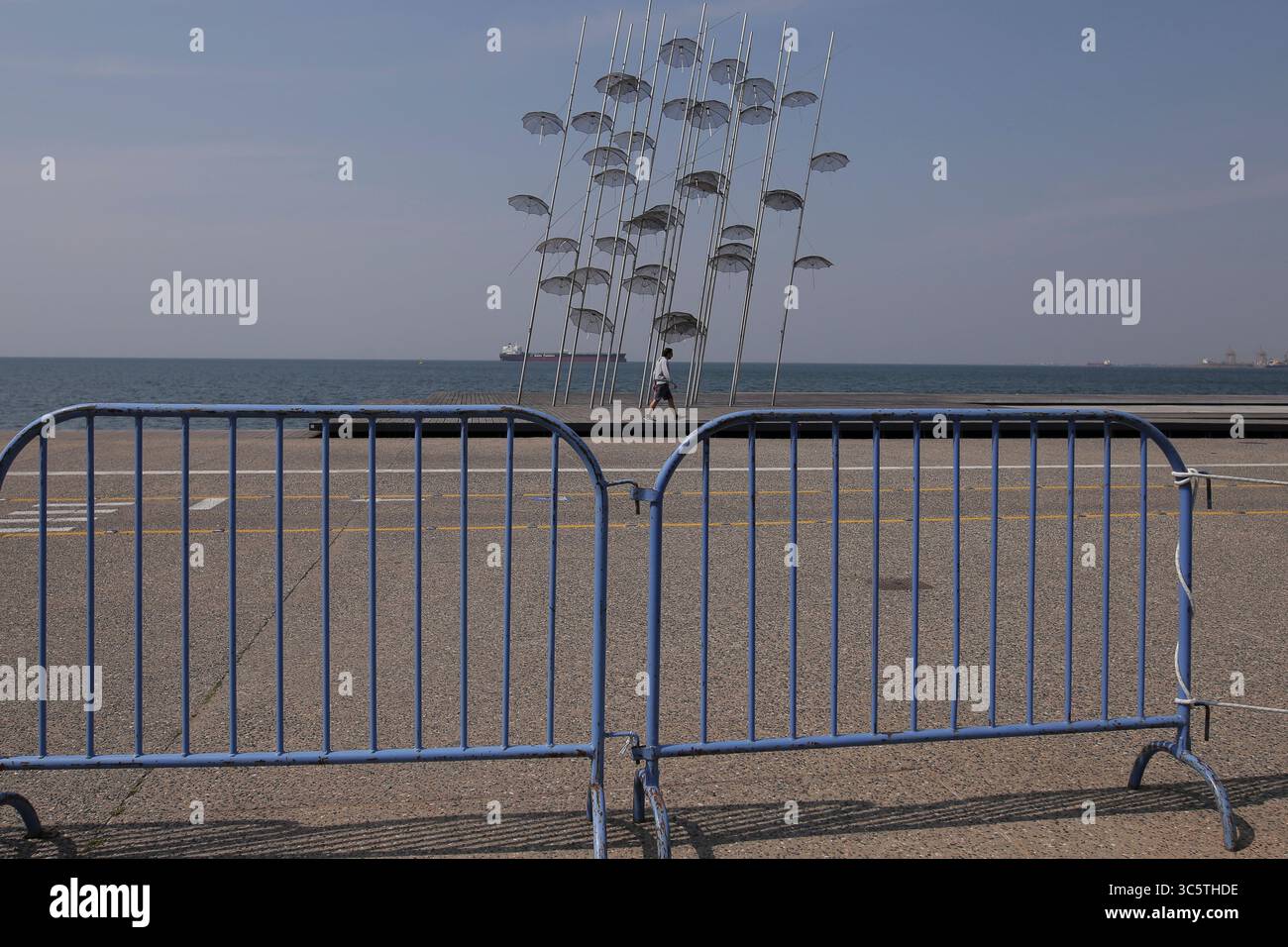 31. März 2020, Thessaloniki, Griechenland: Ein Mann läuft vor den Sonnenschirmen von Zongolopoulos an der Uferpromenade, nachdem beschlossen wurde, den Verkehr an der Uferpromenade zu beschränken. Nikos Chardalias, der stellvertretende Minister für Katastrophenschutz und Krisenmanagement, hat heute Verkehrsbeschränkungen für bestimmte Tageszeiten an der Strandpromenade angeordnet, eine weitere vorbeugende Maßnahme gegen die Ausbreitung von COVID-19 in Griechenland. Diese Maßnahme wurde aufgrund des hohen Verkehrsaufkommens an der Seepromenade von Thessaloniki in den vergangenen Tagen trotz der landesweiten Sperrung beschlossen. (Cred Stockfoto