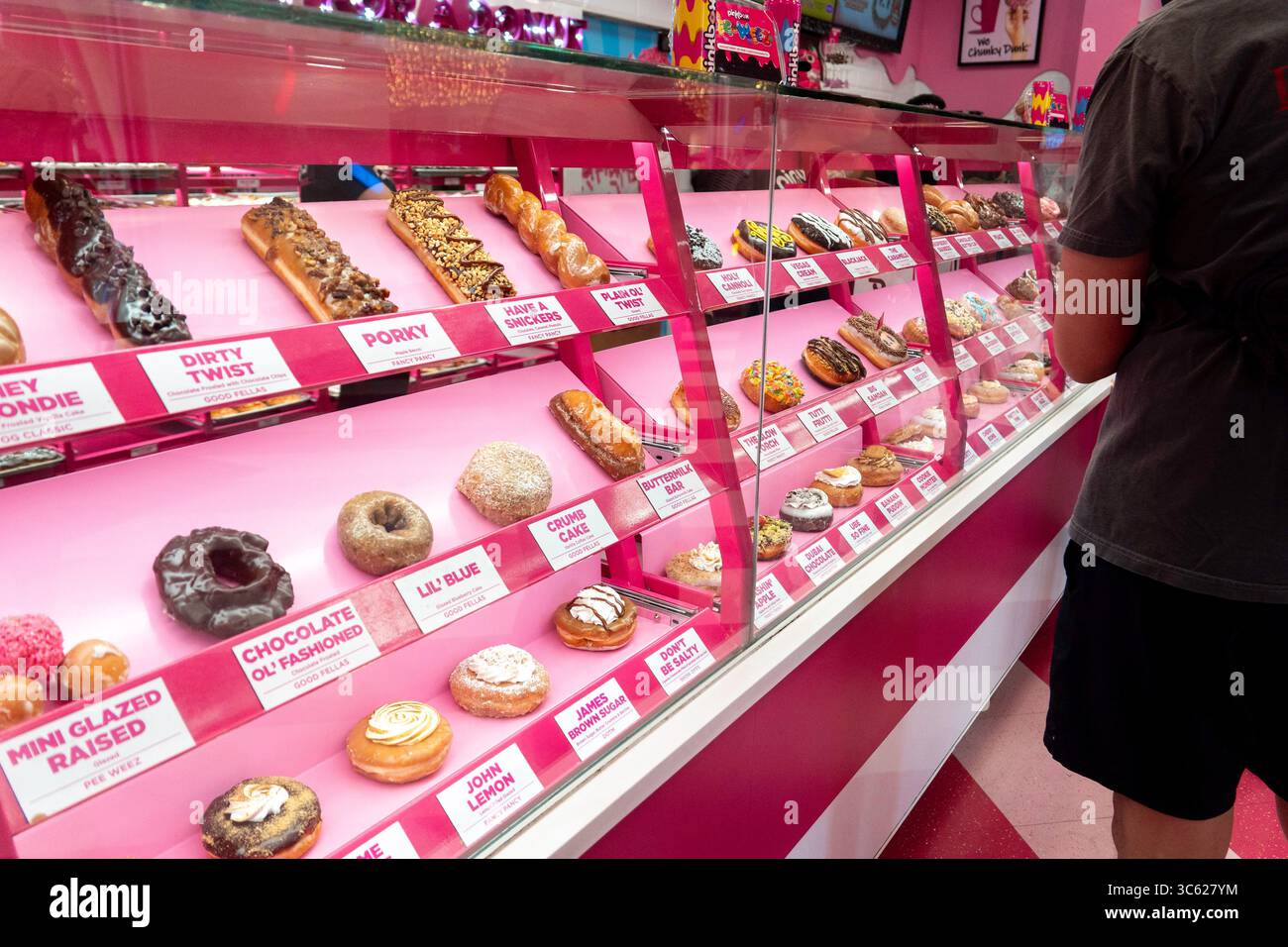 Ein Mann schaut auf eine Vitrine voller Donuts Stockfoto