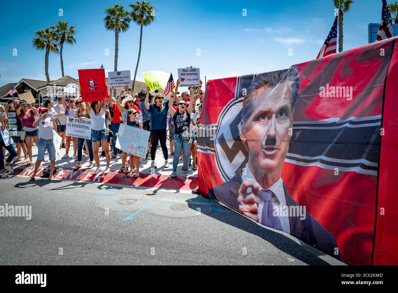 9. Mai 2020, Huntington Beach, Kalifornien, USA: Demonstranten tragen ein großes Banner, das den Staatsregierung mit einem bemalten Hitler-Schnurrbart zeigt. Andere schreien ihre Unterstützung für die Botschaft. Während eines Reopen California Protests in der Nähe des Huntington Beach Pier. (Kreditbild: © Orin Louis/ZUMA Wire) Stockfoto