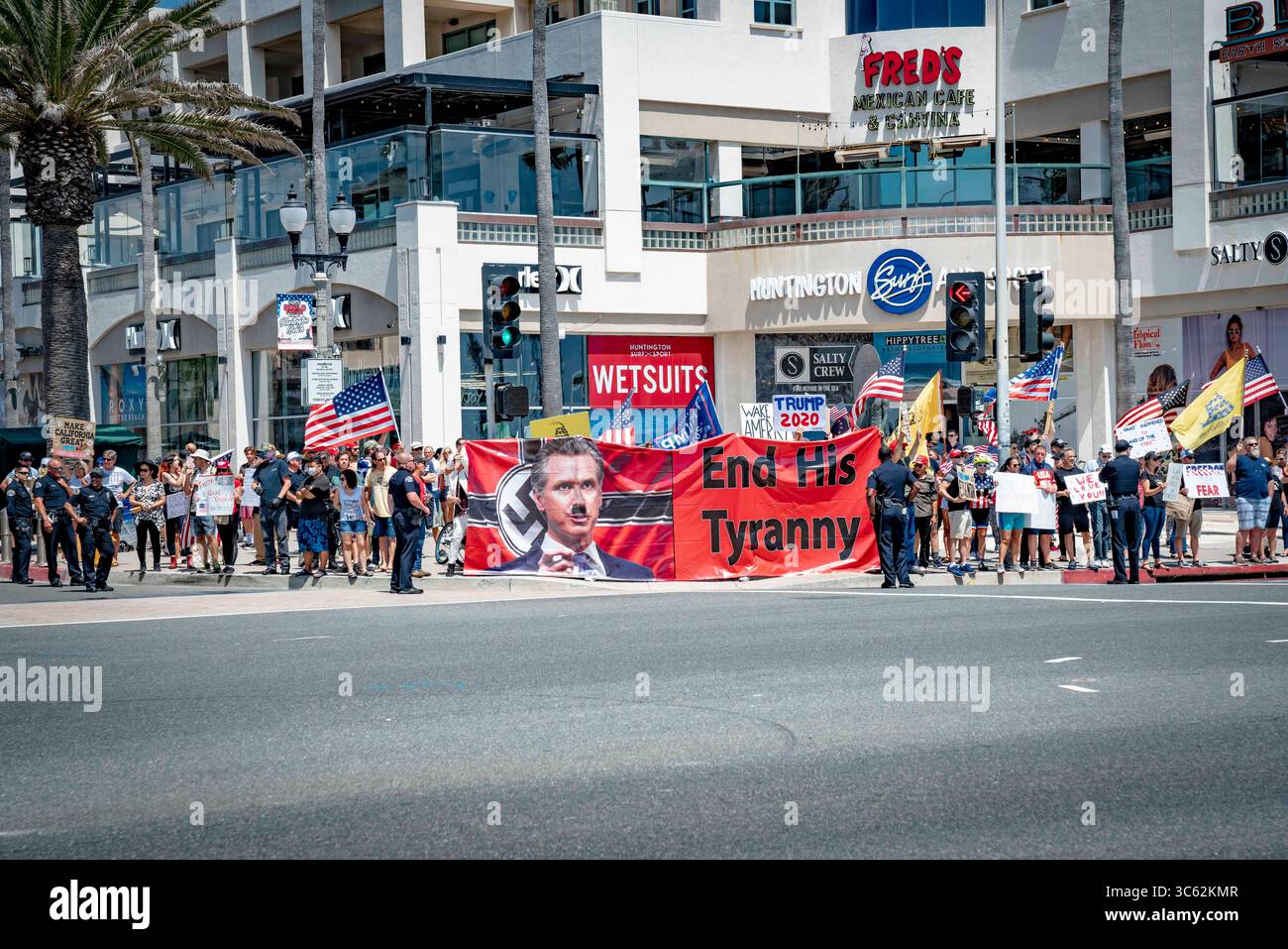 9. Mai 2020, Huntington Beach, Kalifornien, USA: Demonstranten tragen ein großes Banner, das den Staatsregierung mit einem bemalten Hitler-Schnurrbart zeigt. Andere schreien ihre Unterstützung für die Botschaft und schwingen auch Zeichen, die Präsident Trump und seine Partei unterstützen. Während eines Reopen California Protests in der Nähe des Huntington Beach Pier. (Kreditbild: © Orin Louis/ZUMA Wire) Stockfoto