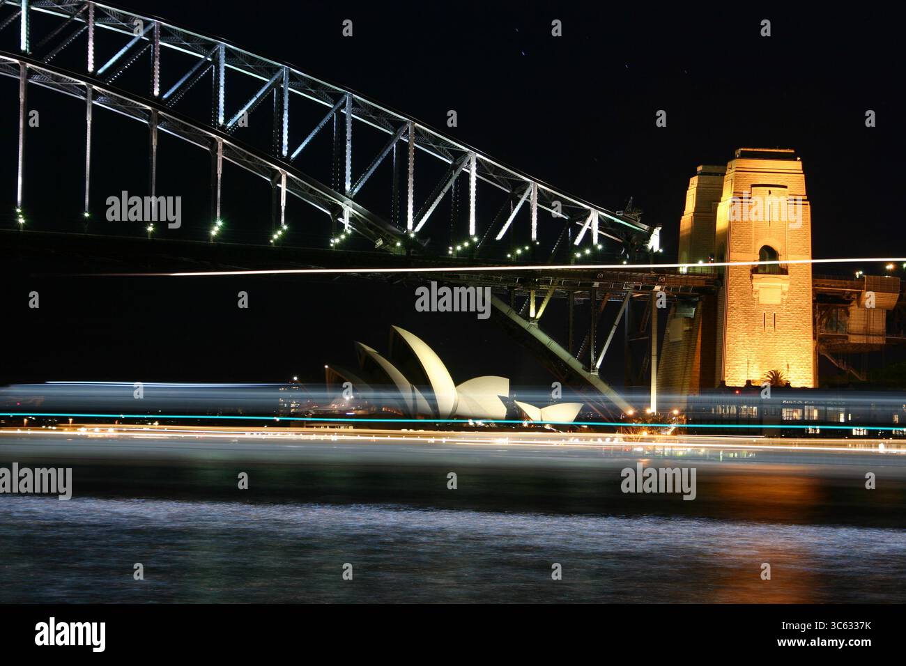 Nächtliche sydney Oper und Brücke mit Lichtern eines vorbeifahrenden Bootes, aufgenommen mit einer langen Exposition Stockfoto