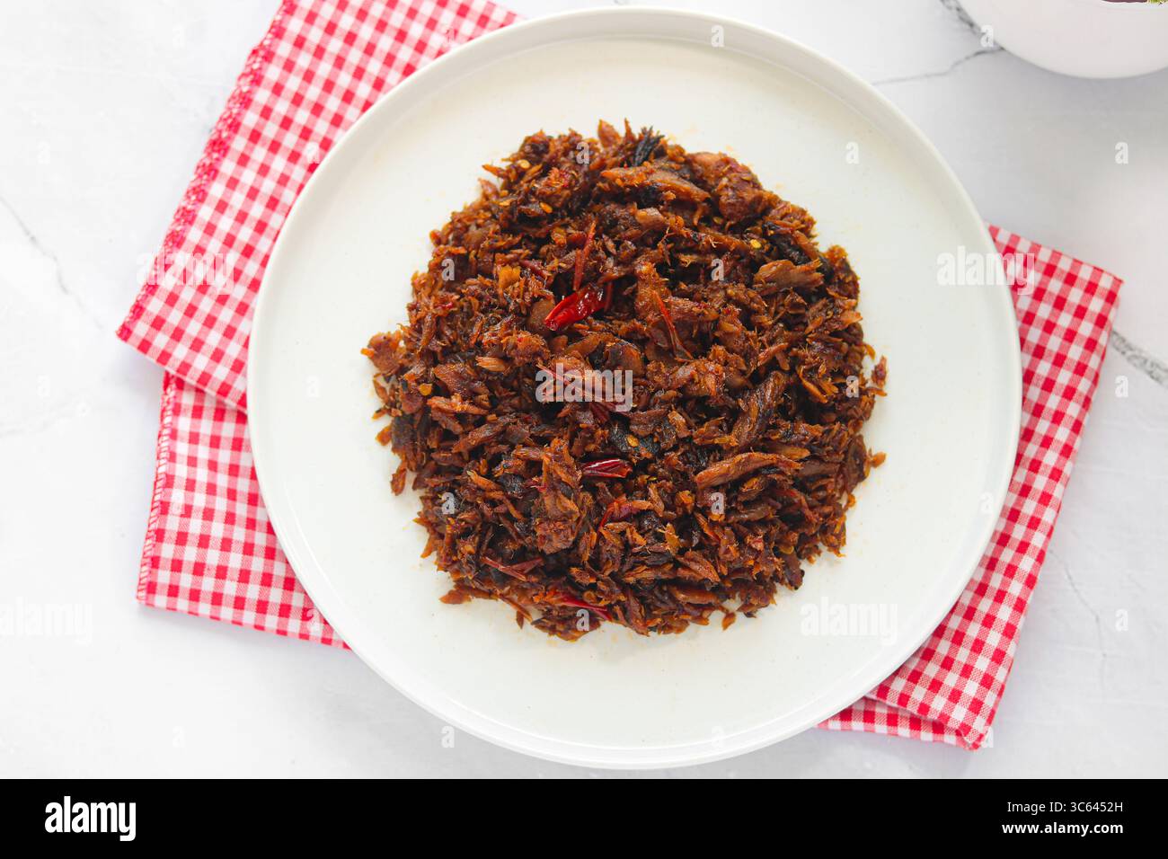 Ein Teller mit geröstetem, geräuchertem Skipjack-Thunfisch mit Chili und Gewürzen (Cakalang Fufu Rabe), eine würzige und würzige Manado-Delikatesse. Stockfoto