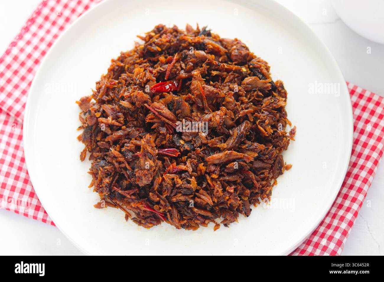 Nahaufnahme eines Tellers mit geräuchertem Skelett-Thunfisch mit Chili und Gewürzen (Cakalang Fufu Rabe), einer scharfen und aromatischen Manado-Delikatesse. Stockfoto