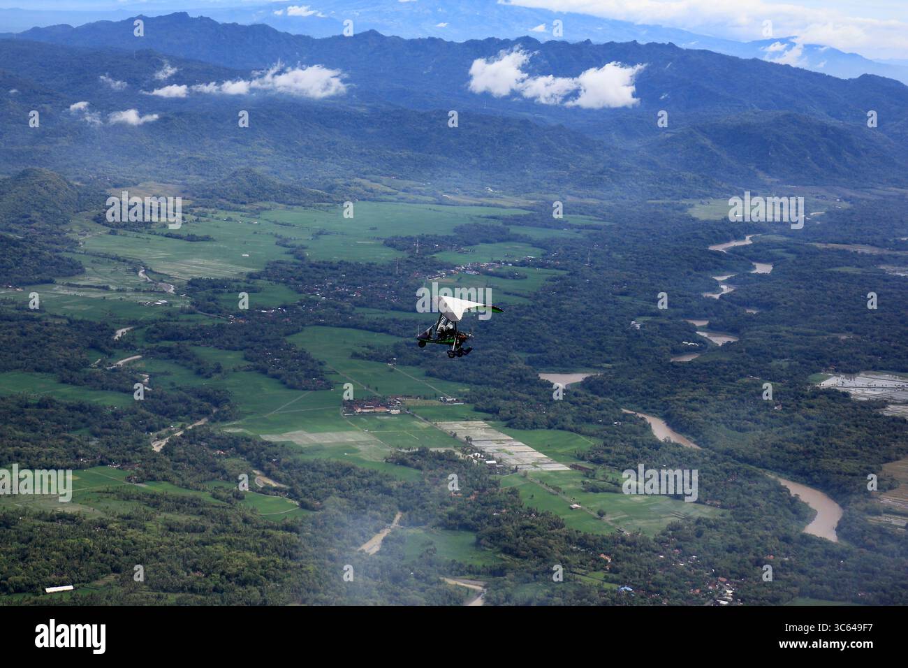 Mikrolichtflugzeuge fliegen über grüne und üppige Naturlandschaften sowie über den berühmten Fluss Kali Progo, Kulanprogo. Stockfoto