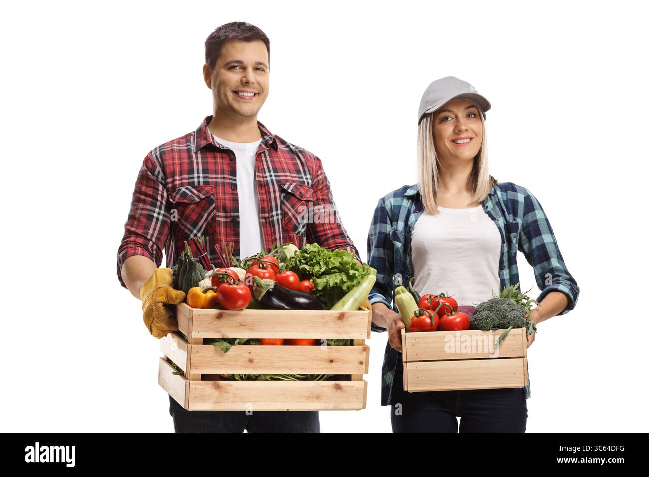 Junger Mann und Frau, die Kisten voller Gemüse auf weißem Hintergrund halten Stockfoto