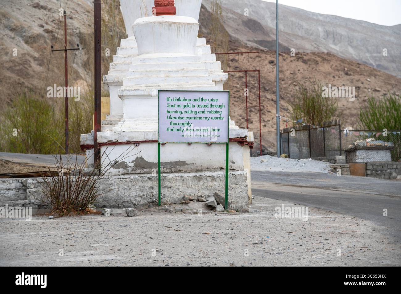 Buddha-Zitat auf einem Schild an einer Straßenkreuzung in Ladakh, Indien, das Frieden, Weisheit und Spiritualität in einer Bergkulisse fördert. Stockfoto