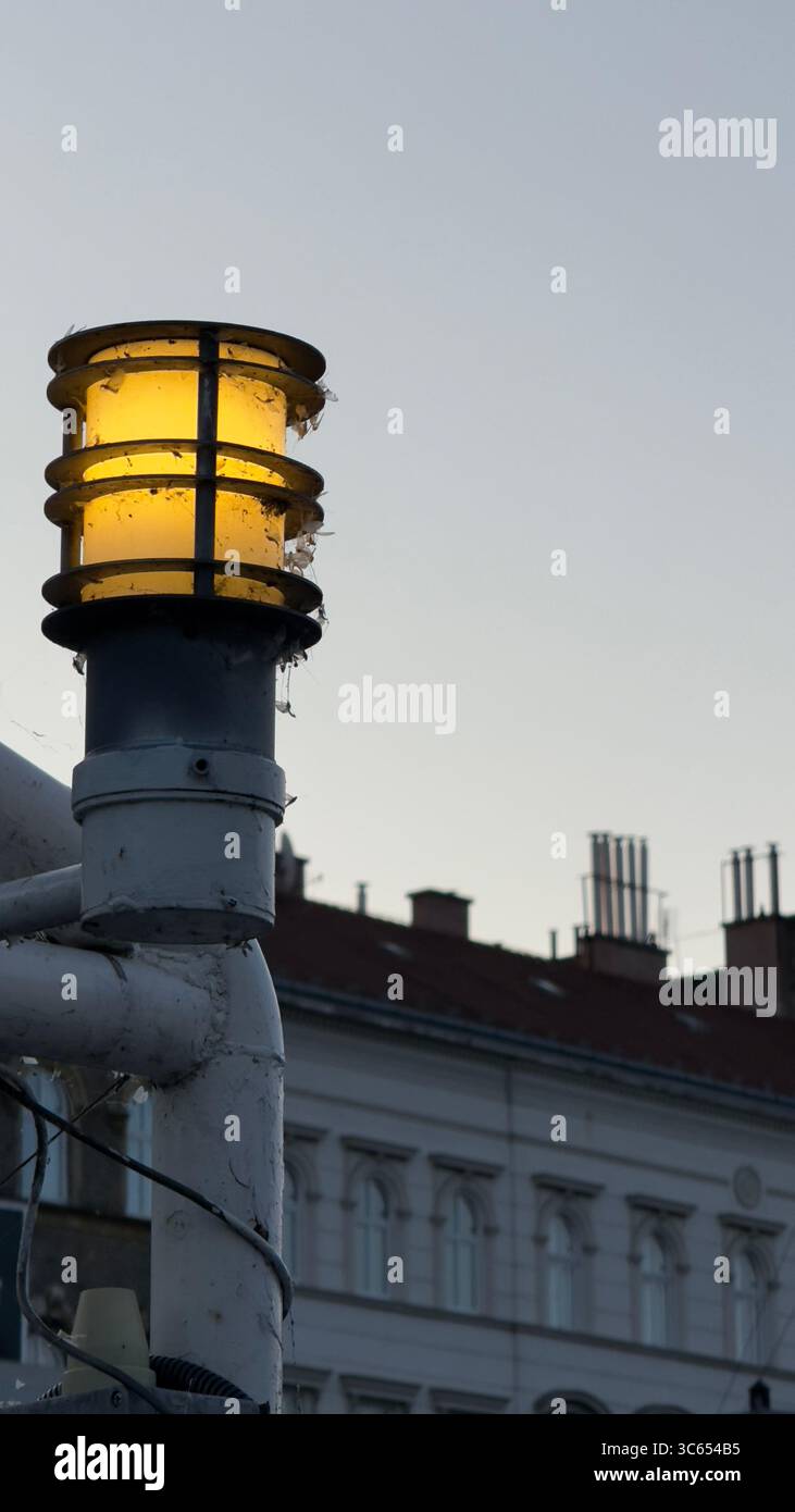 Leuchtende Außenscheinwerfer auf einem Donaudamm-Ponton in Budapest, Ungarn, mit historischen Gebäuden im Hintergrund. Stockfoto